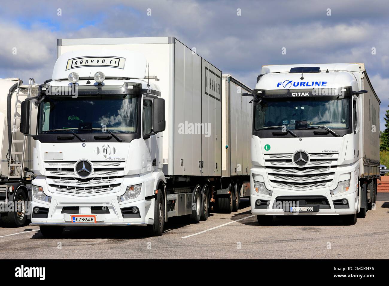 Deux poids lourds Mercedes-Benz Actros blancs stationnés sur un arrêt de camion, avec la Finlande et la semi-remorque avec plaques de dinde. Salo, Finlande. 30 juillet 2022. Banque D'Images