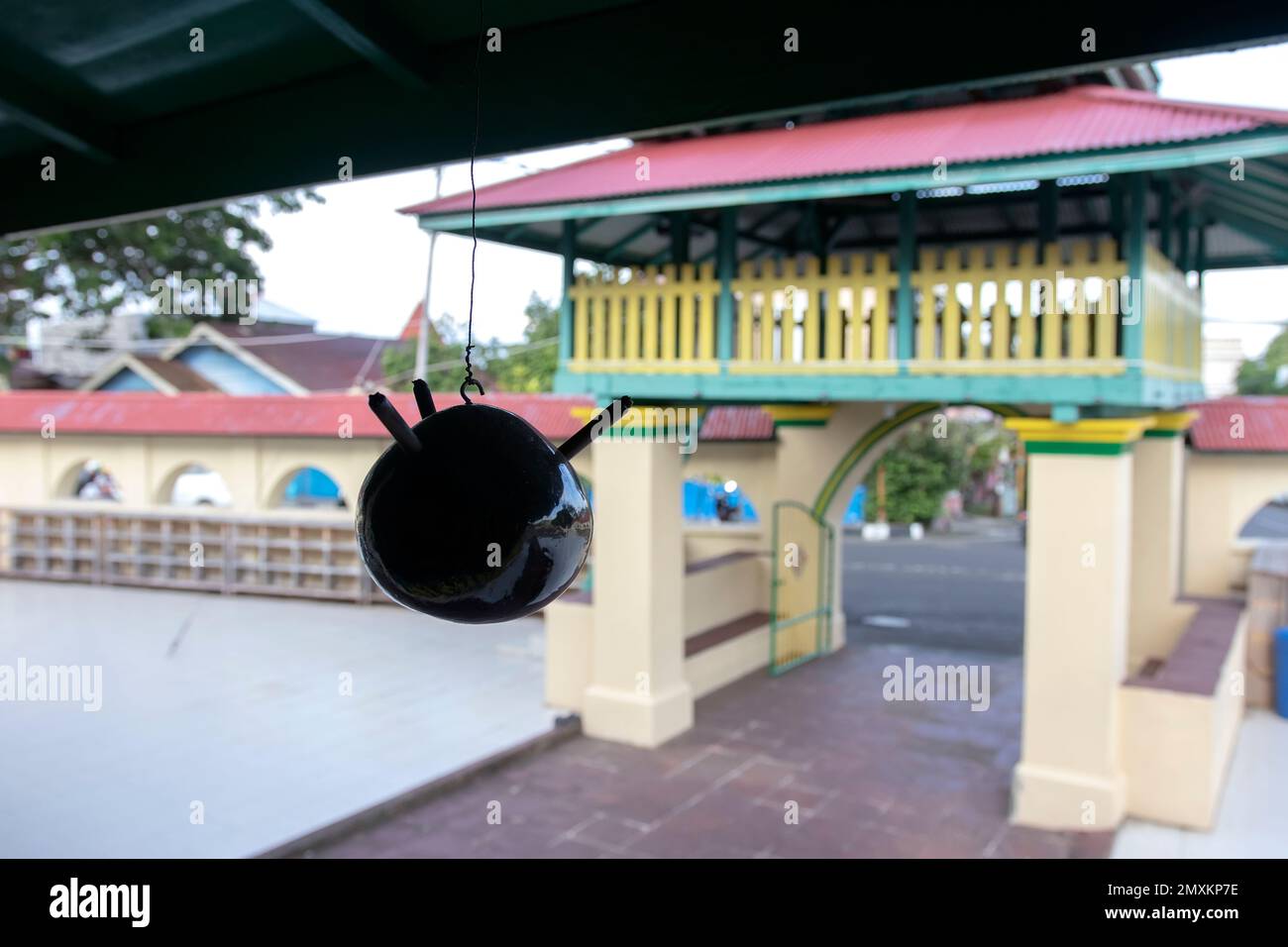 La silhouette d'une simple lampe traditionnelle accrochée sur le fond d'une porte de mosquée dans la ville de Ternate. Banque D'Images