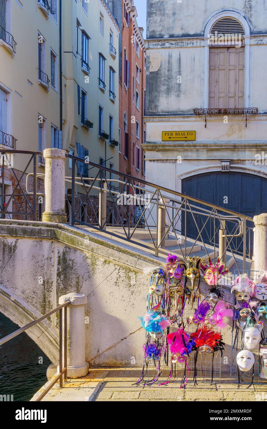 Vue sur les masques traditionnels de carnaval en vente, canal, pont, bâtiments, et panneau directionnel, À Venise, Vénétie, Italie du Nord Banque D'Images