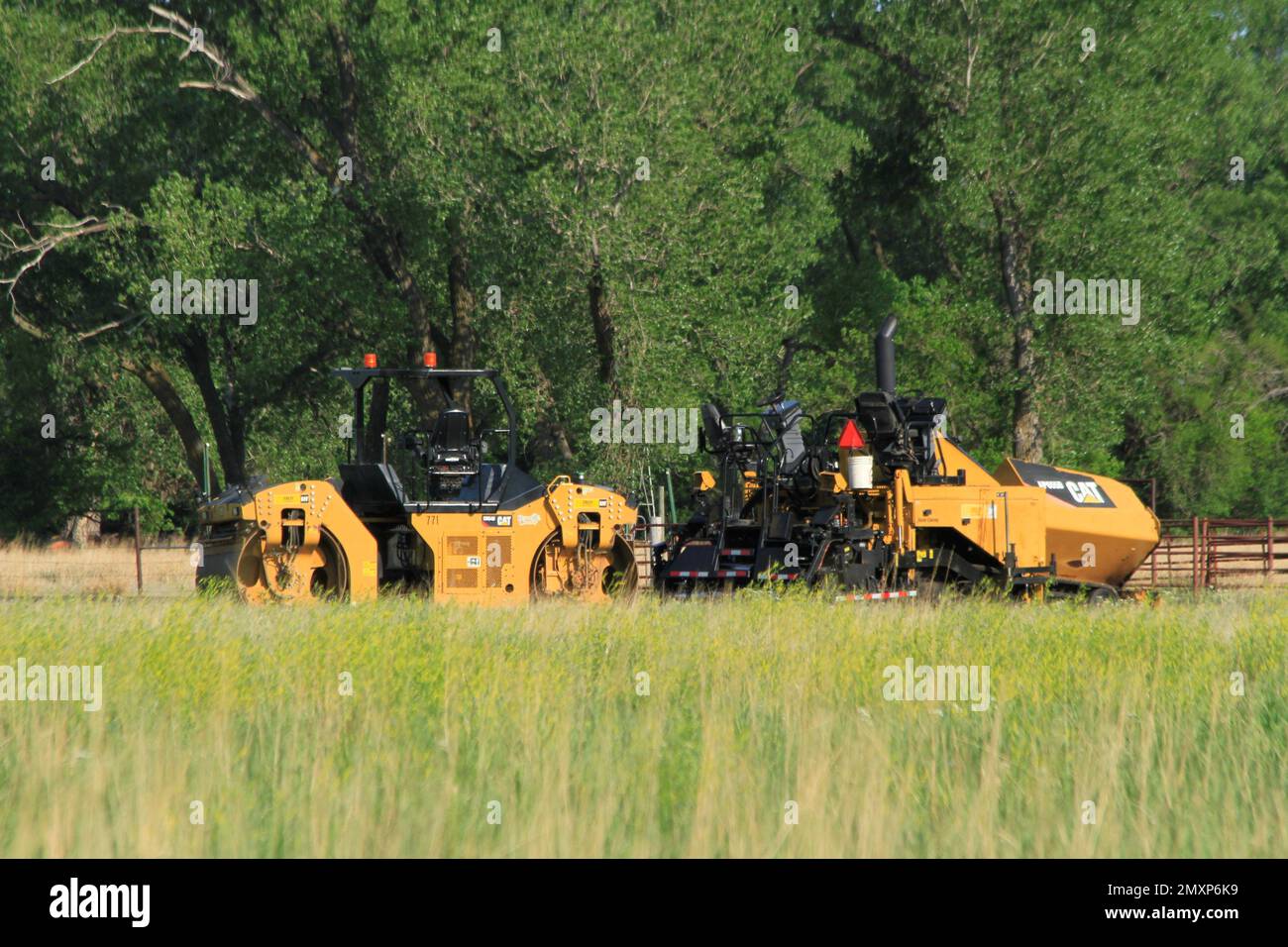 Équipement lourd CAT pour travaux sur route stationnés dans un champ Banque D'Images
