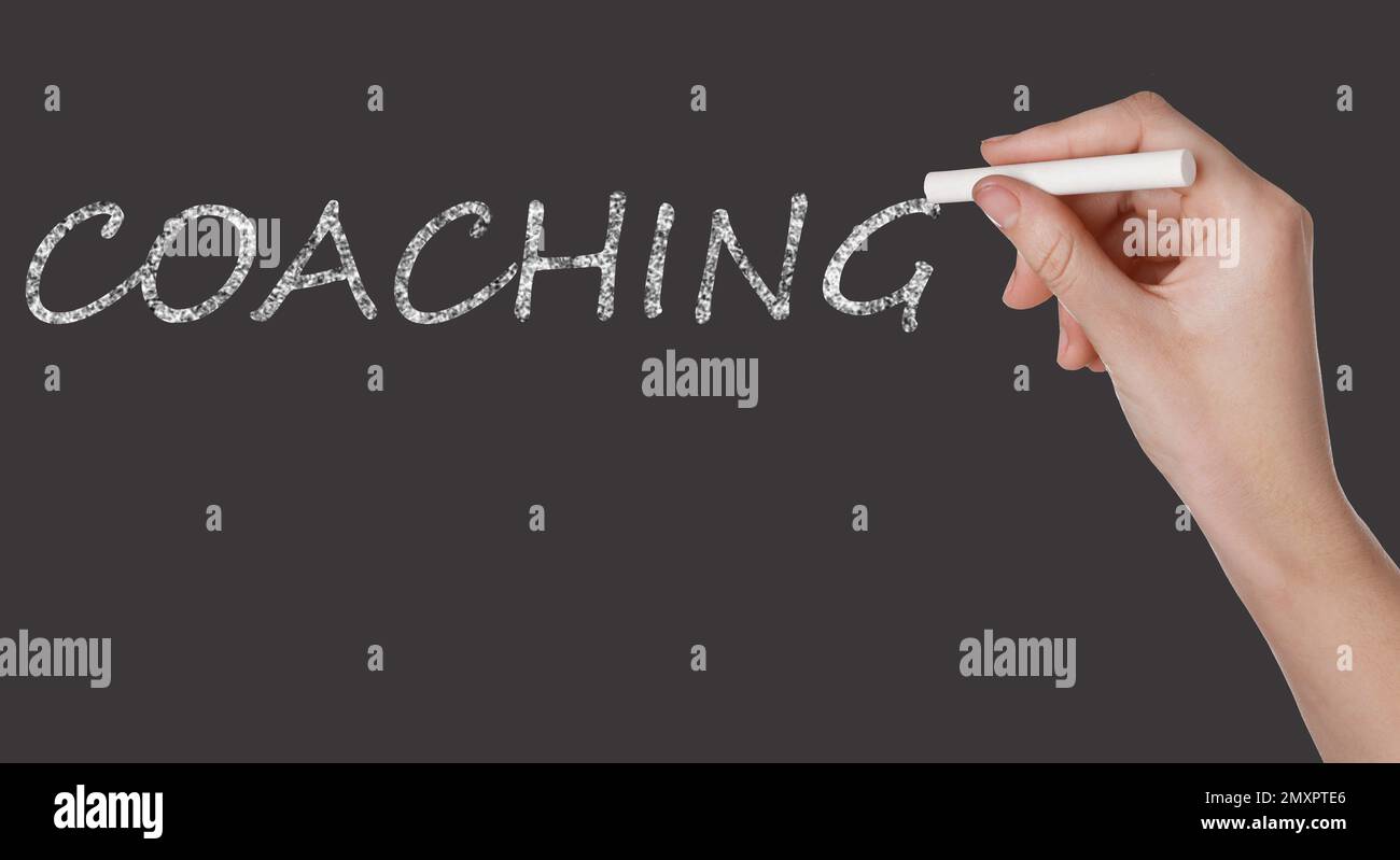 Entraîneur d'affaires ou de vie écrivant le mot Coaching sur le tableau noir, gros plan. Bannière Banque D'Images