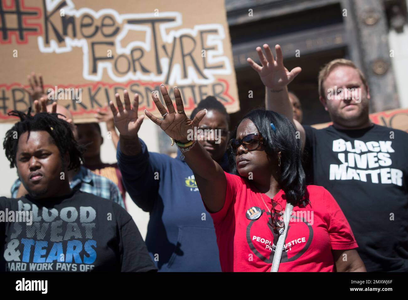 Demonstrators holds their hands up in support during a rally for Tyre