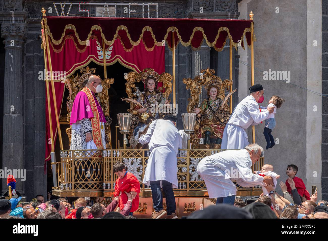 La Festa di Sant'Alfio a lieu début mai dans la ville sicilienne de Trecastagni, près de Catane. Les enfants sont remis au prêtre pour être bénis et embrasser les images des trois saints patrons, les frères romains martyrisés Alfio, Filadelfo et Cirino Banque D'Images
