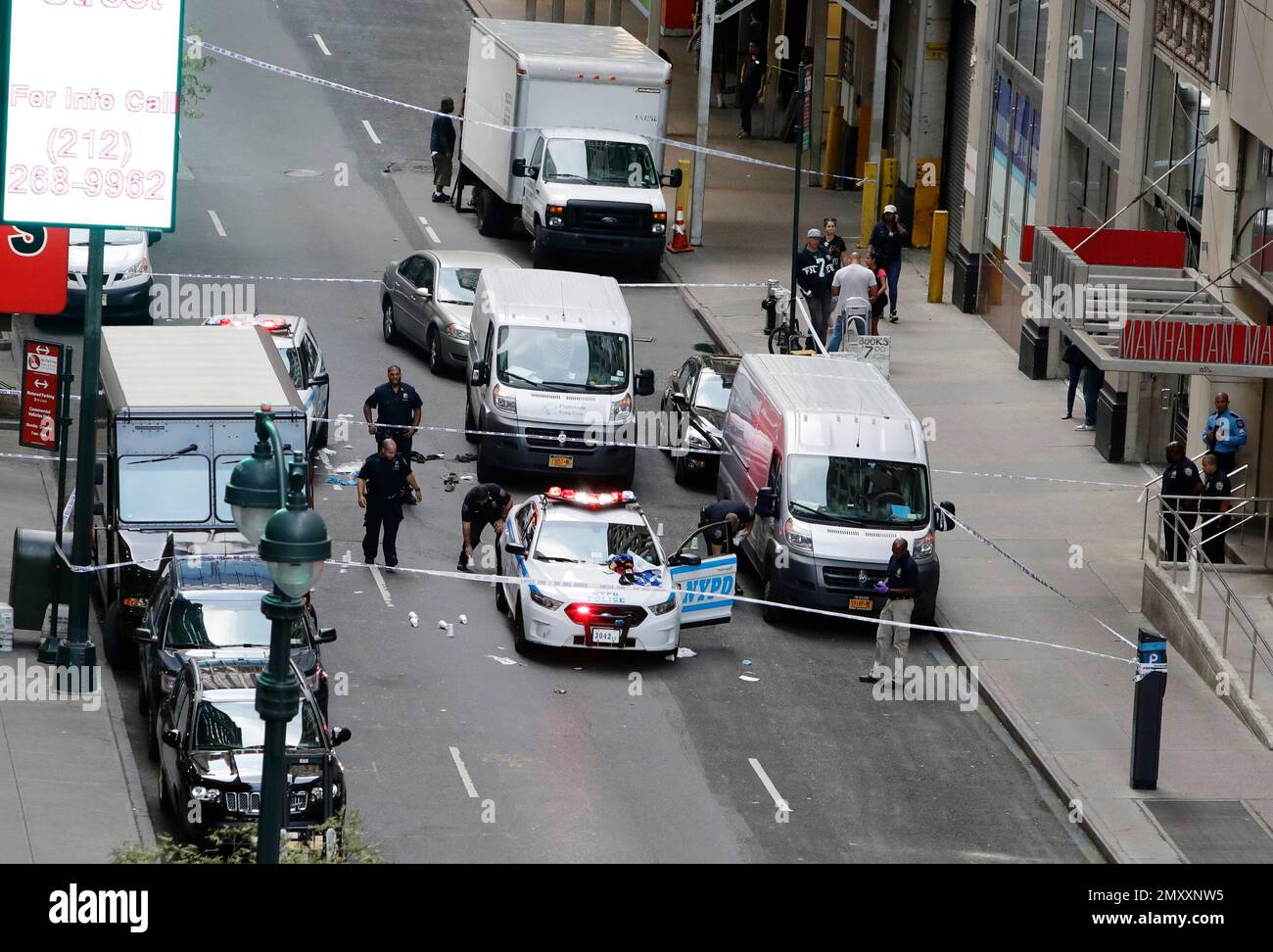 Police officers work a crime scene on west 32nd street Thursday, Sept. 15, 2016, in New York. New York City police say a man attacked a police officer with a meat cleaver in midtown Manhattan and was shot at least twice during a struggle with officers trying to subdue him. The gunshots rang out about a block from Macy’s department store just as rush hour was getting underway Thursday. (AP Photo/Frank Franklin II) Banque D'Images