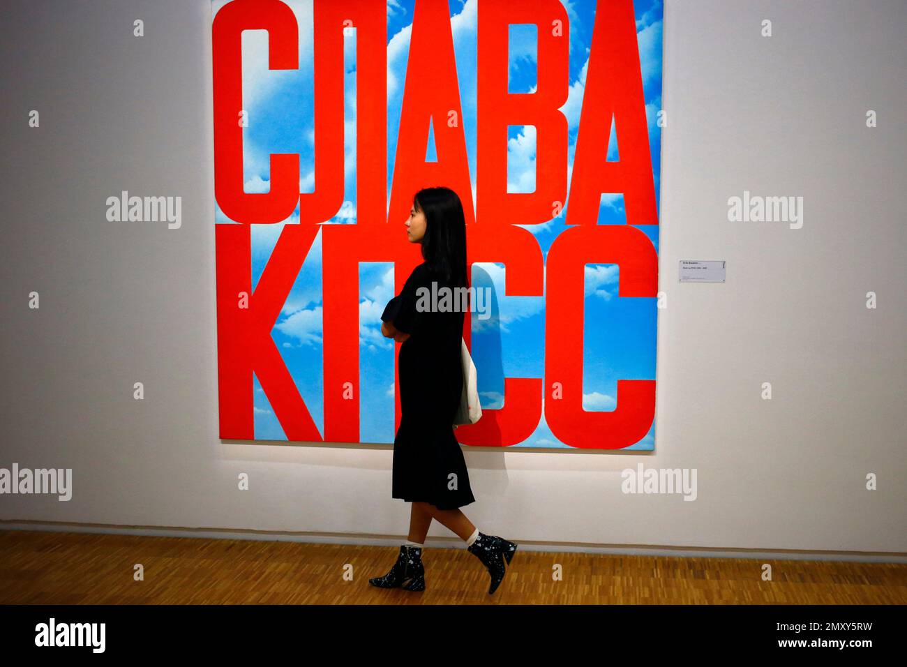 In this photo dated Monday, Sept. 12, 2016 a visitor passes by an oil painting "Gloire au PCUS, 2003-2005" by Erik Bulatov (1933) during the presentation of the Kollektsia exhibition dedicated to Russian contemporary art at Beaubourg Museum in Paris, France. One of the richest oligarchs in Russia, Vladimir Potanin, is donating over 250 works of Russian and Soviet art to France national modern art museum, the Pompidou Center, to promote cultural understanding. The exhibition runs through Sept. 14, 2016 to March 27, 2017. (AP Photo/Francois Mori) Banque D'Images