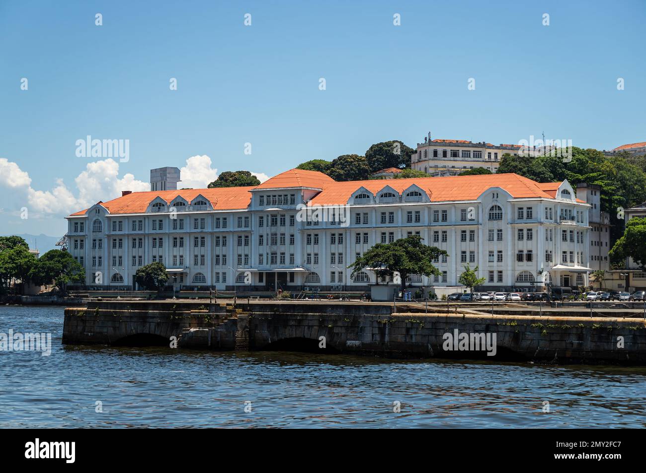 Vue sur le grand bâtiment Almirante Gastao Motta situé sur l'île d'Ilha das Cobras, sur les eaux de la baie de Guanabara sous l'après-midi d'été ciel bleu clair. Banque D'Images