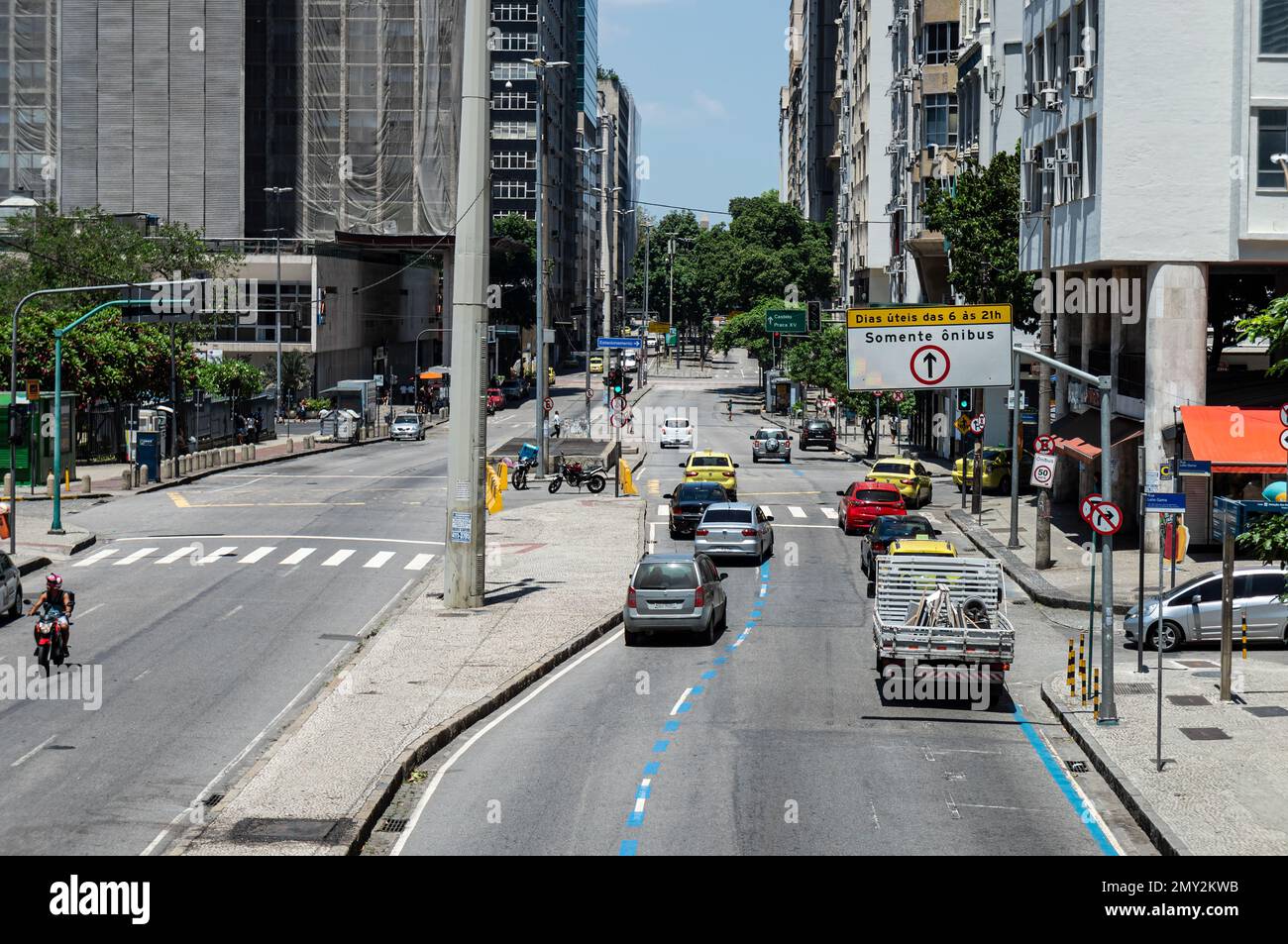 Trafic passant par l'avenue Almirante Barroso dans le quartier Centro entre les bâtiments commerciaux de haute élévation sous l'été après-midi ensoleillé ciel bleu clair. Banque D'Images