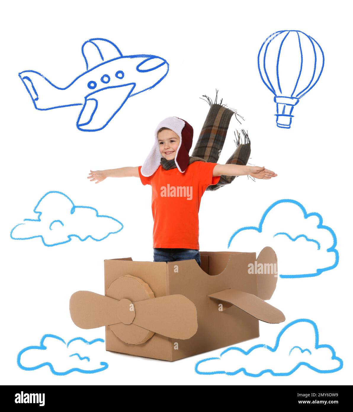Mignon petit enfant jouant dans un avion en carton sur fond blanc avec des illustrations Banque D'Images