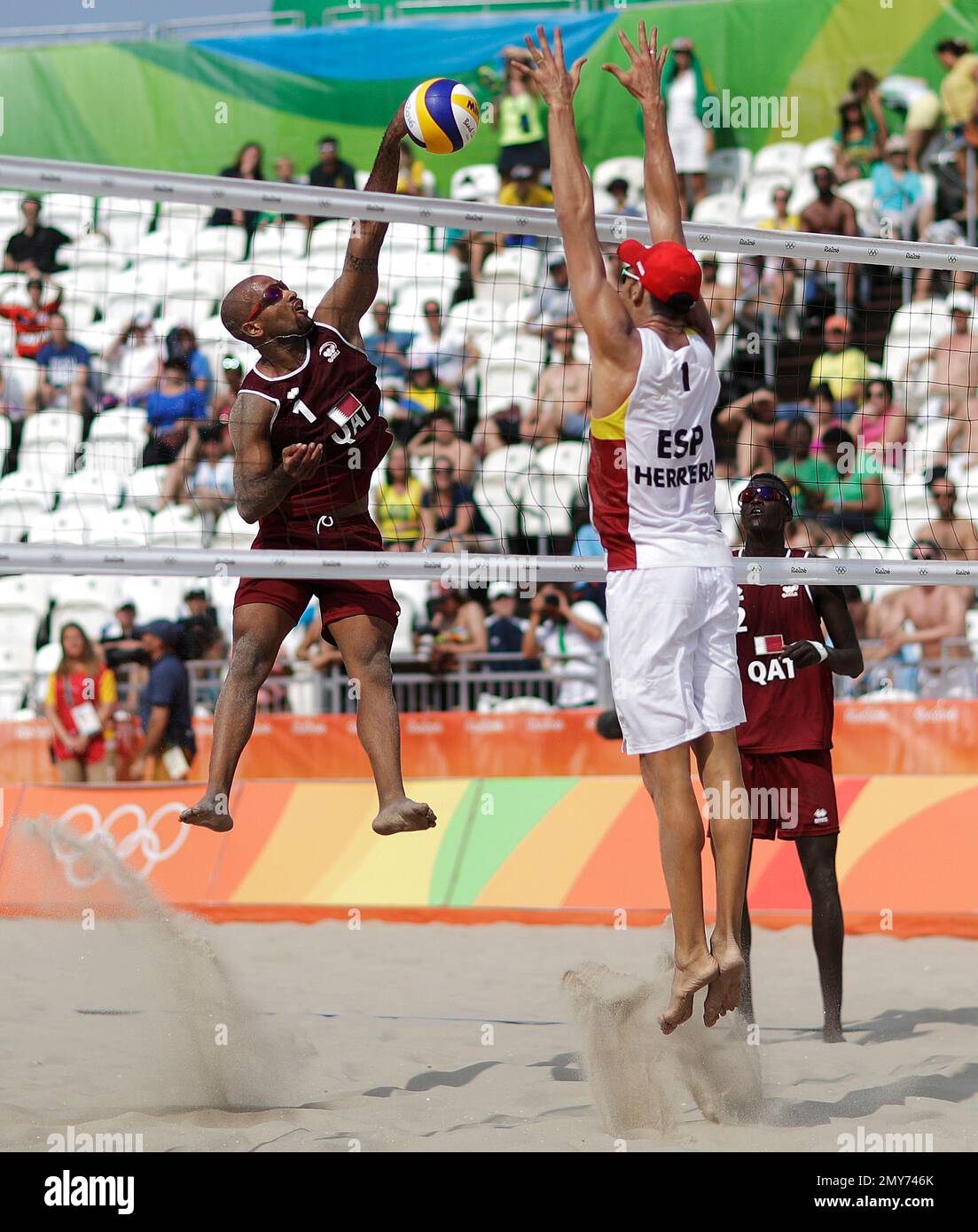 Qatar's Jefferson Santos Pereira, left, spikes the ball against Spain's Pablo Herrera Allepuz in a men's beach volleyball match at the 2016 Summer Olympics in Rio de Janeiro, Brazil, Monday, Aug. 8, 2016. (AP Photo/David Goldman) Banque D'Images