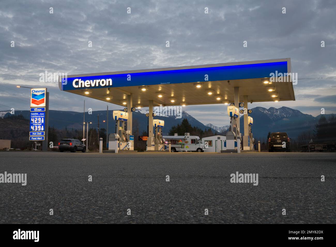 Sultan, WA, Etats-Unis - 1 février 2023 ; station-service Chevron illuminée en face des montagnes en WA Banque D'Images