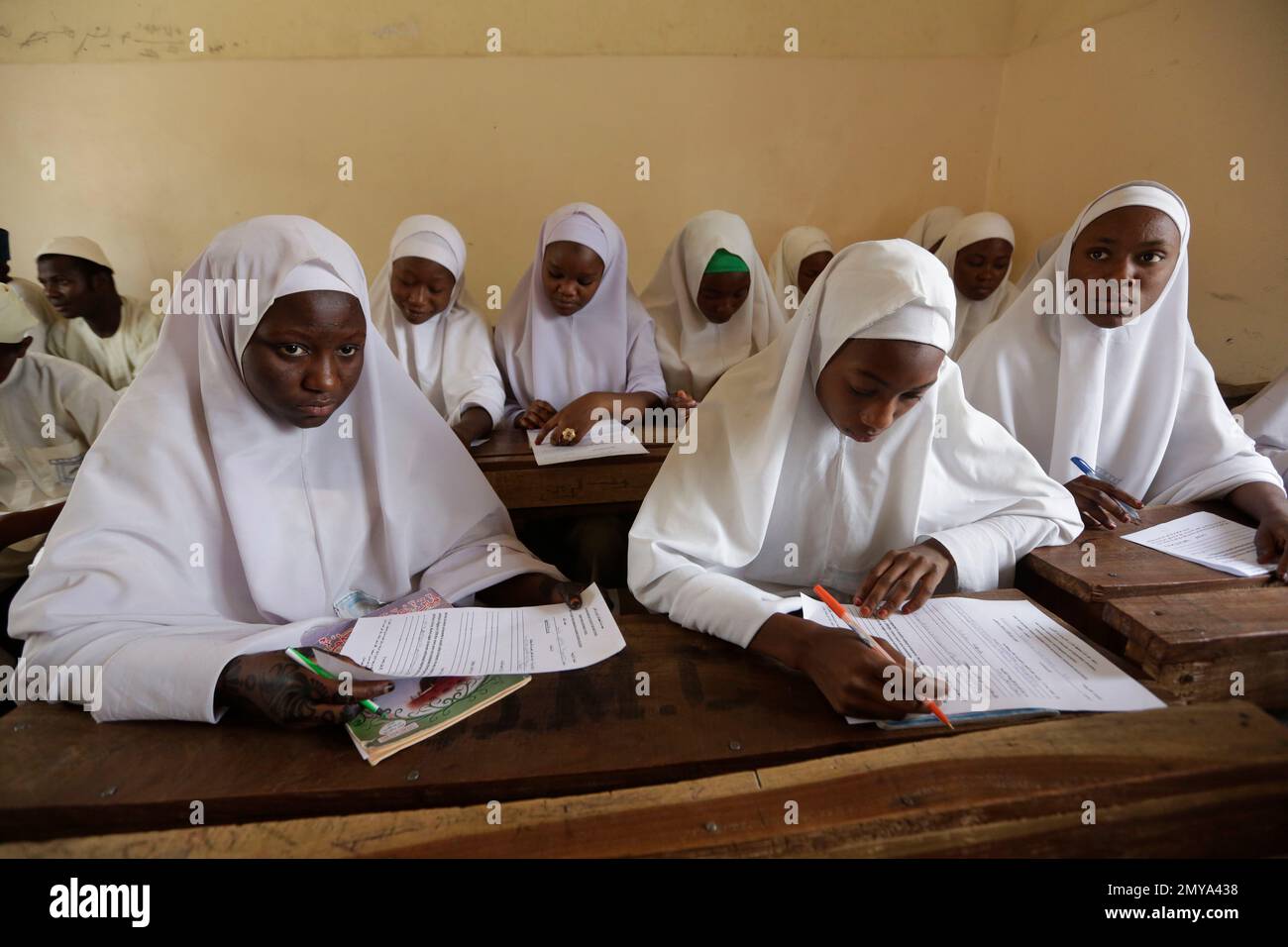 In this photo taken Wednesday April. 6, 2016 Muslim girls take exams in a school in Kano, Nigeria. Nigerian girls have the right to wear the hijab headscarf to school, an appeals court has ruled in a country where suicide bombers have abused Islamic dress to hide their deadly weapons. (AP Photo/Sunday Alamba) Banque D'Images