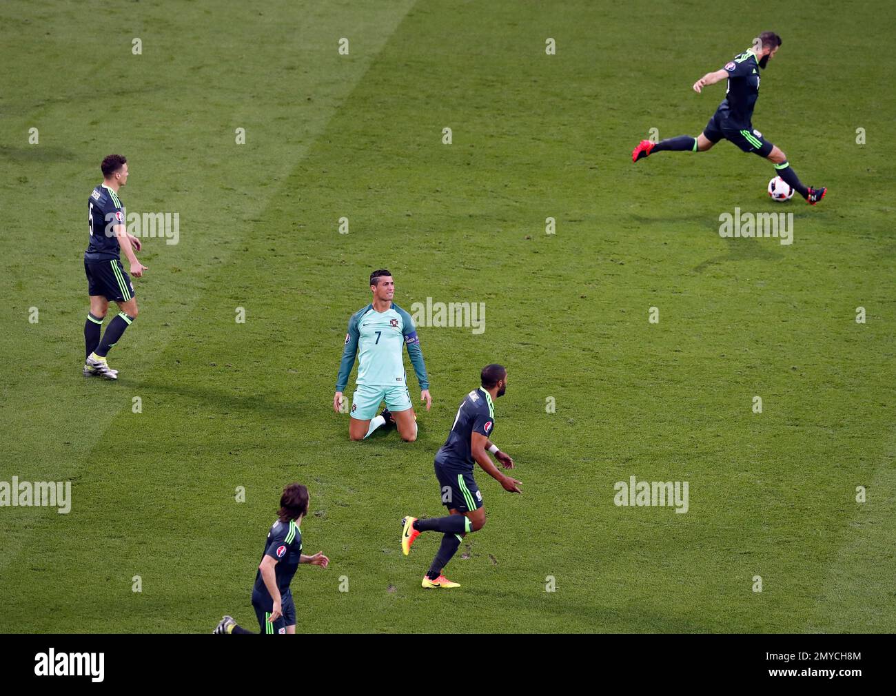 Portugal's Cristiano Ronaldo, center, reacts after being tackled by Wales players during the Euro 2016 semifinal soccer match between Portugal and Wales, at the Grand Stade in Decines-Charpieu, near Lyon, France, Wednesday, July 6, 2016. (AP Photo/Francois Mori) Banque D'Images
