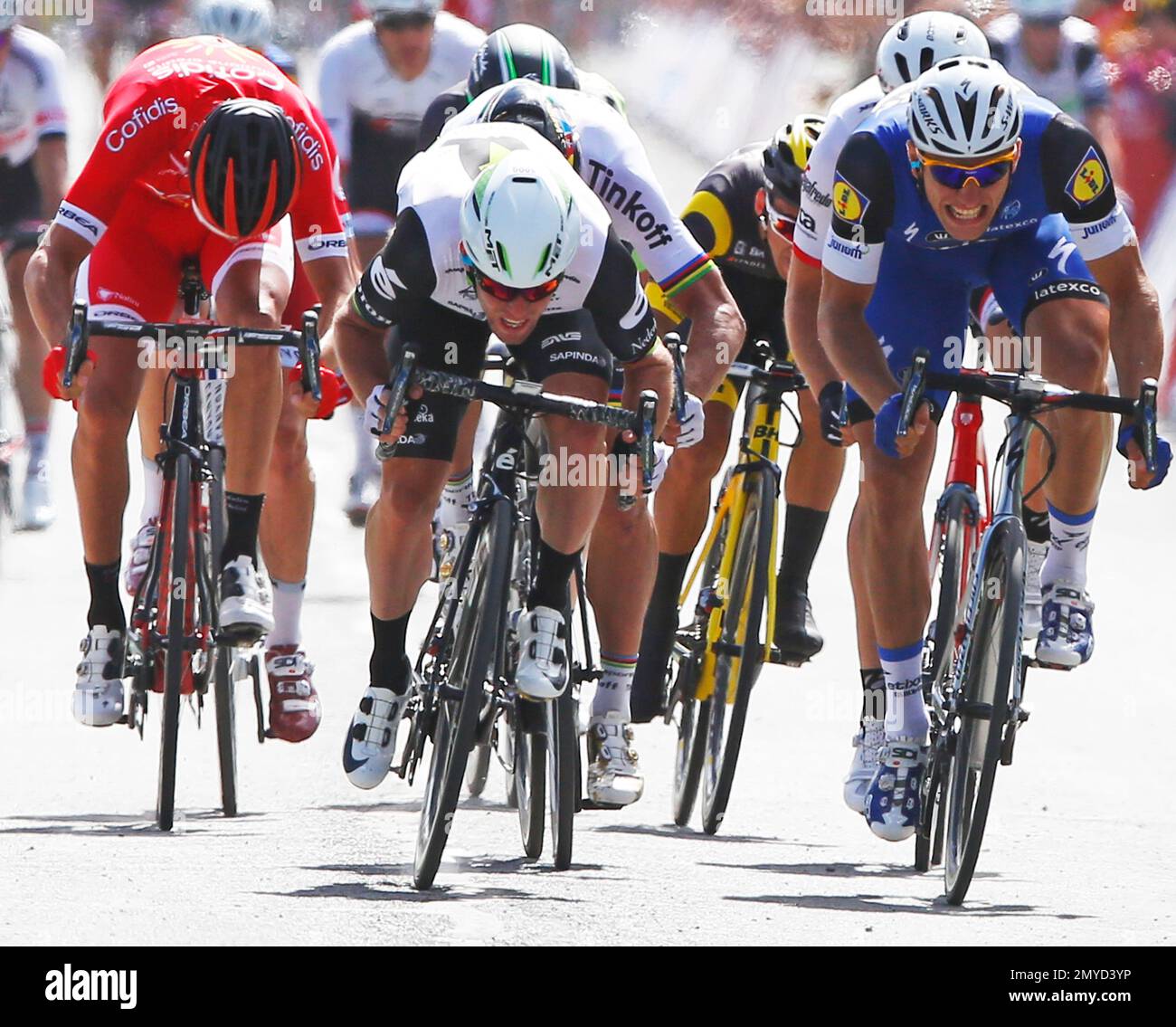 Britain's Mark Cavendish, center, sprints towards the finish line ahead of Germany's sprinter Marcel Kittel, right, to win the first stage of the Tour de France cycling race over 188 kilometers (116.8 miles) with start in Mont-Saint-Michel and finish in Utah Beach, France, Saturday, July 2, 2016. (AP Photo/Peter Dejong) Banque D'Images