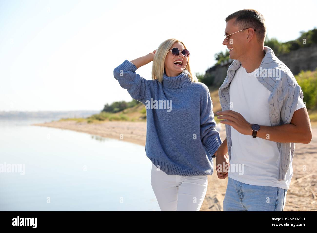 Couple heureux en pulls élégants sur la plage Banque D'Images