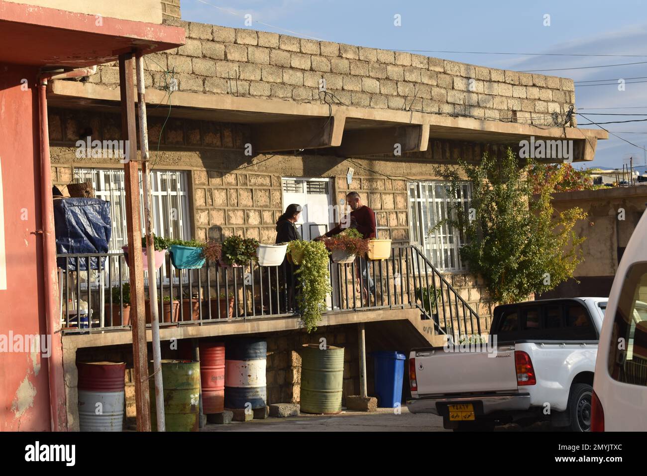 Un couple sur le balcon de leur maison de village dans le Kurdistan irakien Banque D'Images