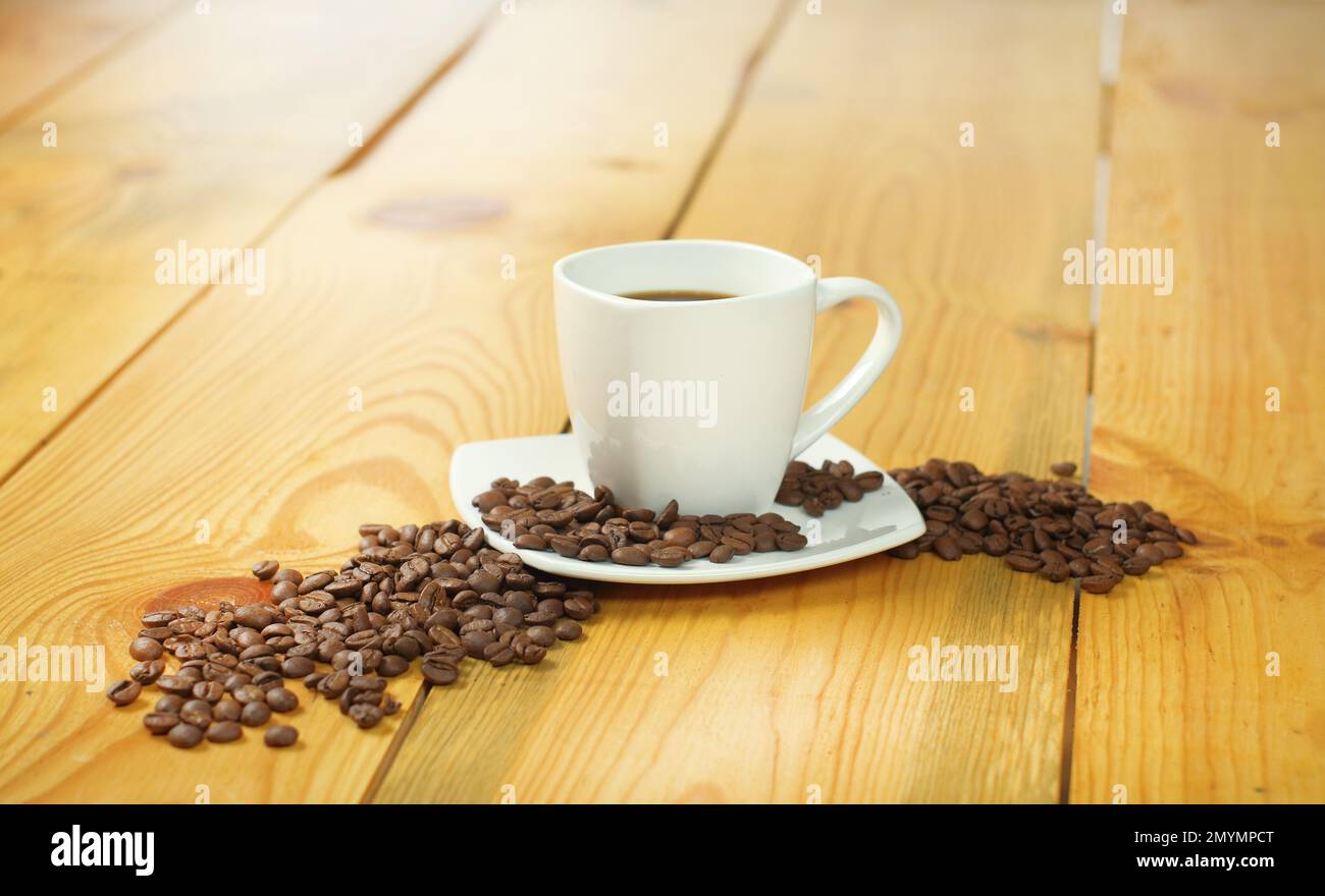 tasse de café avec grains de café sur une table en bois Banque D'Images