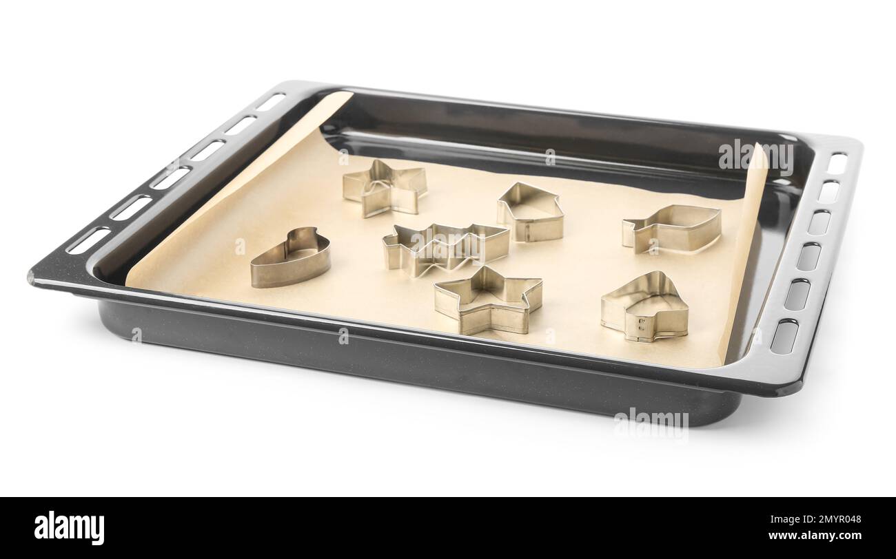 Plaque de cuisson avec coupe-papier et biscuit sur fond blanc Banque D'Images