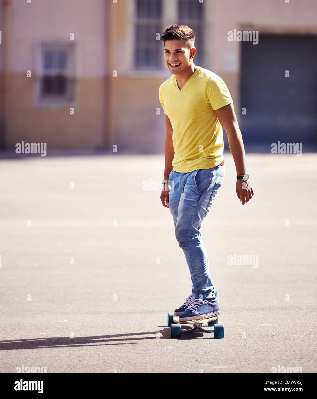 Prêt à tirer sa prochaine astuce. un jeune homme qui fait du skateboard dans un parc de skate. Banque D'Images