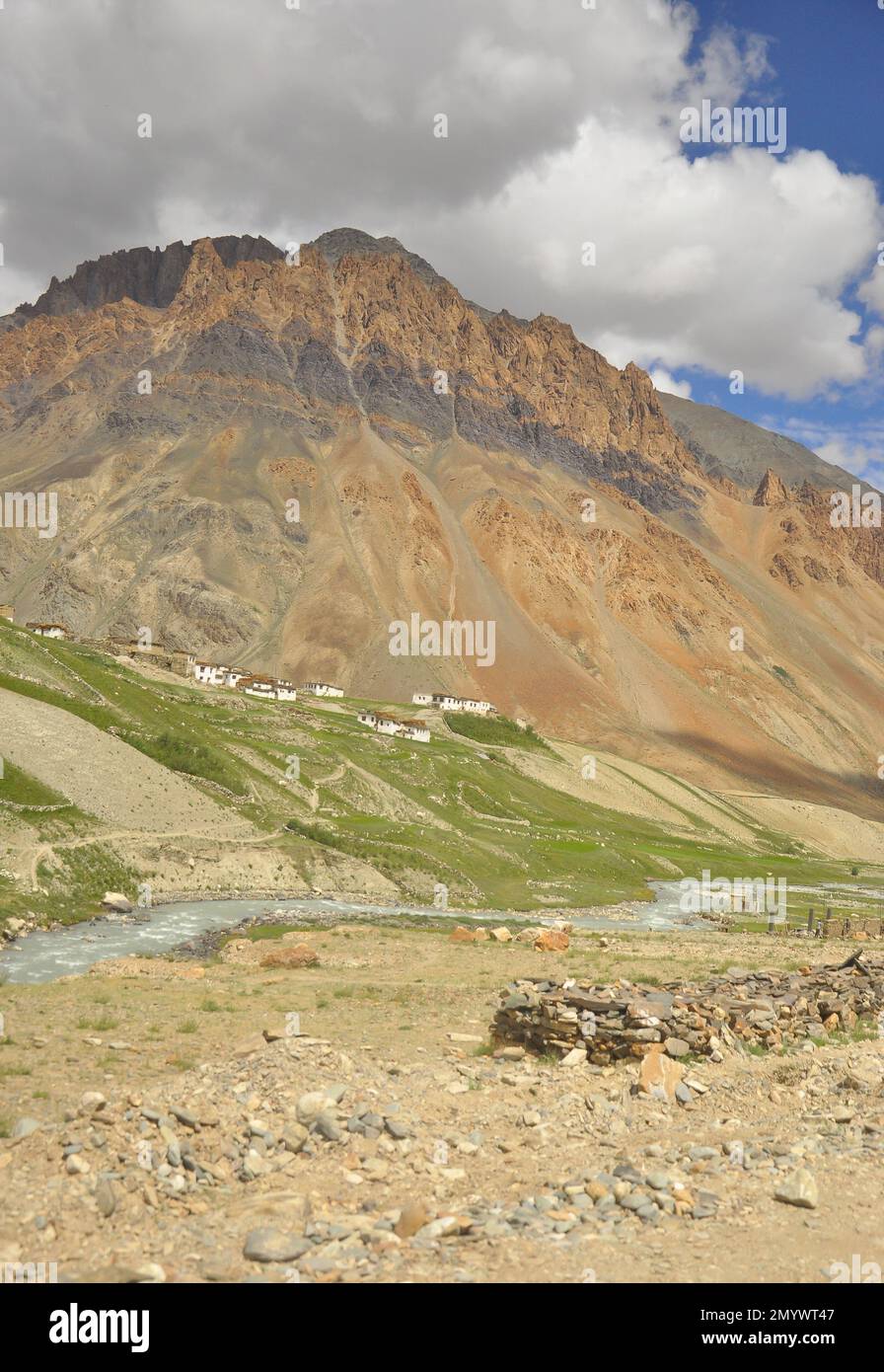 Vue sur un village à côté d'une belle montagne rocheuse avec une rivière coulant sur la route de Darcha-Padum, Ladakh, INDE. Banque D'Images