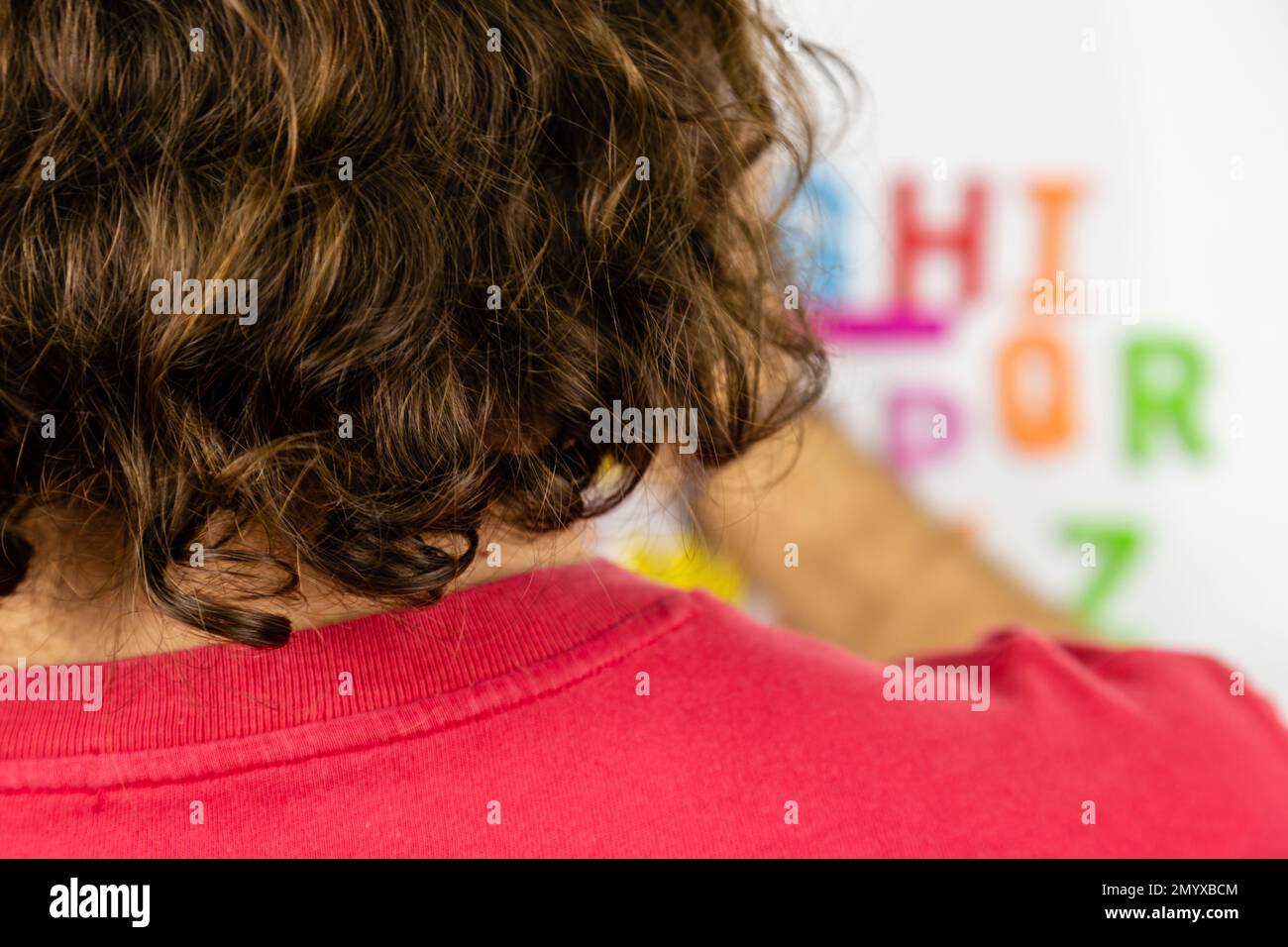 Au-dessus de l'épaule de la personne regardant les aimants de l'alphabet Banque D'Images
