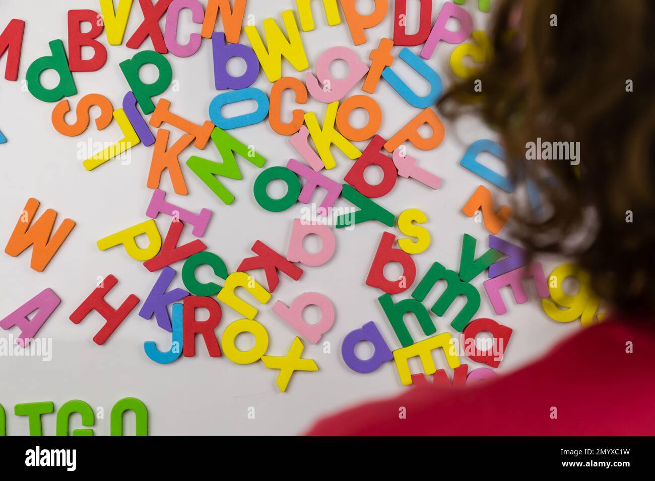 Au-dessus de l'épaule de la personne regardant les aimants de l'alphabet Banque D'Images