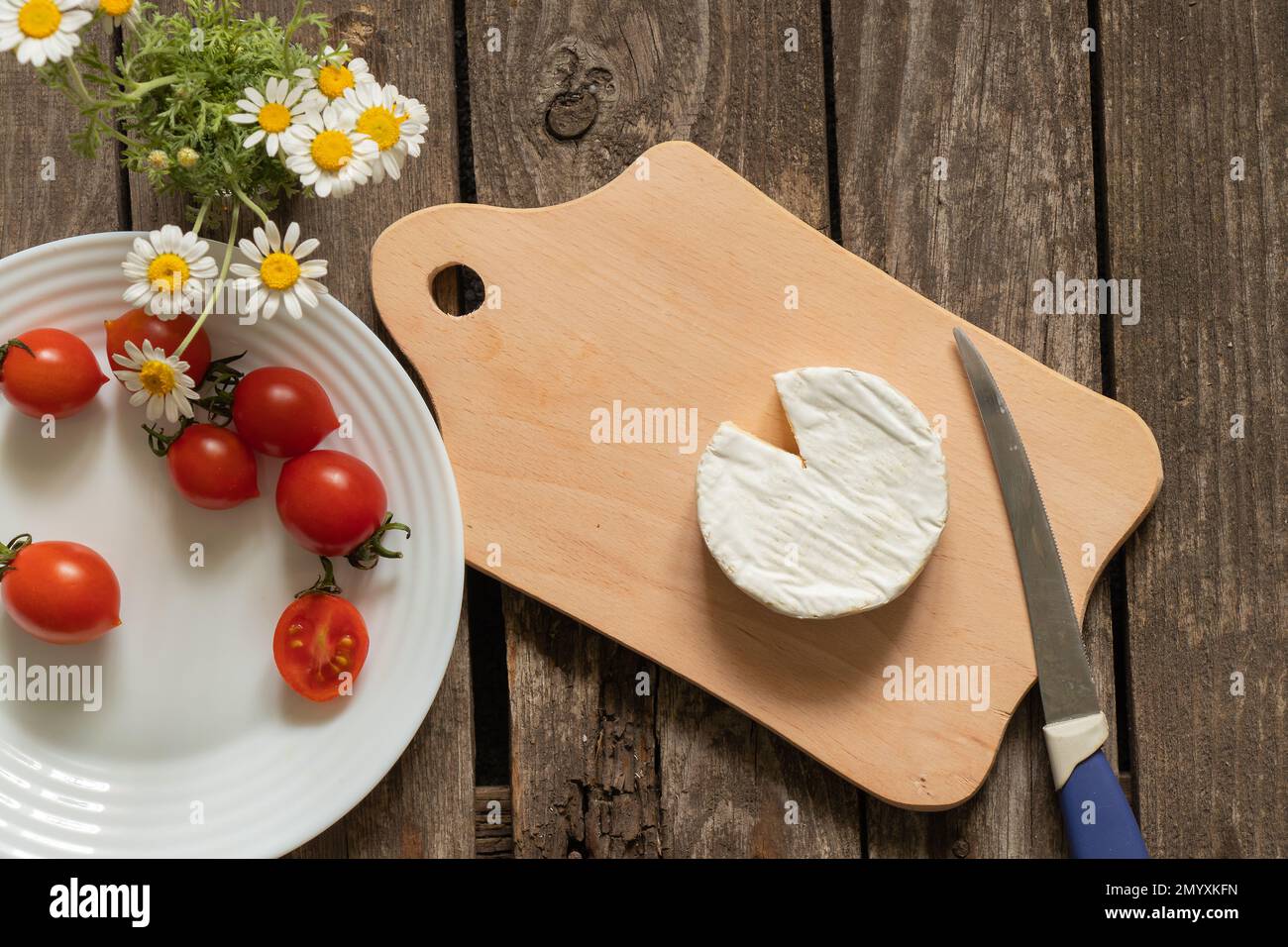 fromage brie doux et tomates cerises sur une table Banque D'Images