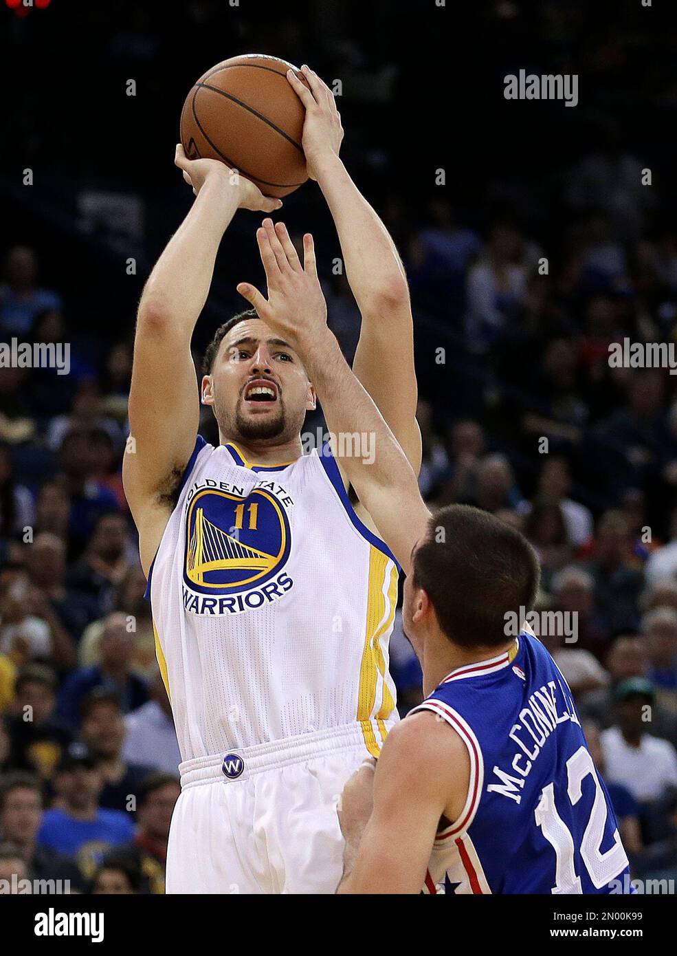 Golden State Warriors' Klay Thompson shoots over Philadelphia 76ers' T.J. McConnell (12) during the second half of an NBA basketball game, Sunday, March 27, 2016, in Oakland, Calif. (AP Photo/Ben Margot) Banque D'Images
