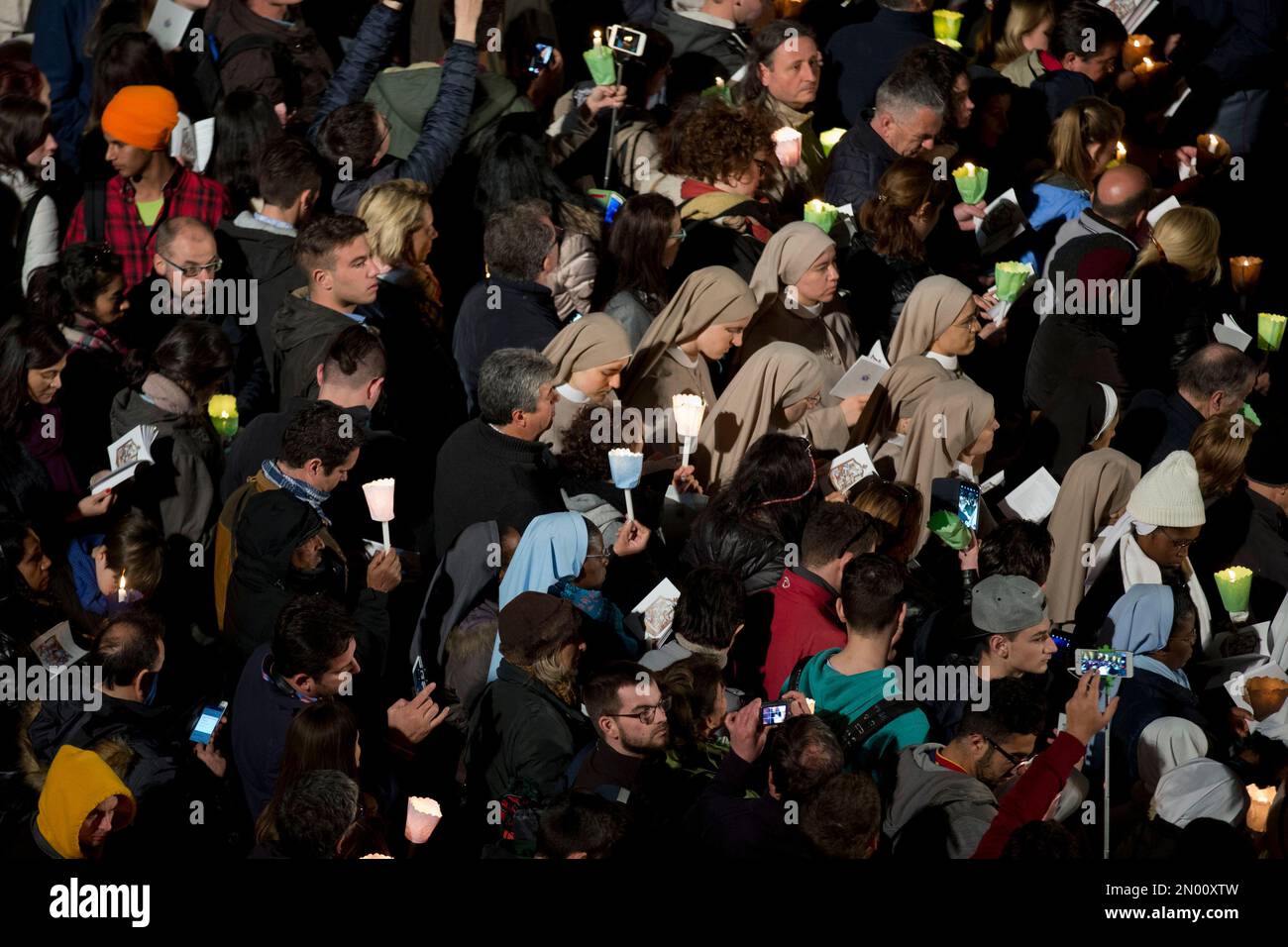 Faithful hold candles and prayer books during the Via Crucis (Way of the Cross) torchlight procession celebrated in front of the Colosseum on Good Friday in Rome, Friday, March 25, 2016. The evening Via Crucis procession at the ancient amphitheater is a Rome tradition that draws a large crowd of faithful, including many of the pilgrims who flock to the Italian capital for Holy Week ceremonies before Easter Sunday. (AP Photo/Andrew Medichini) Banque D'Images