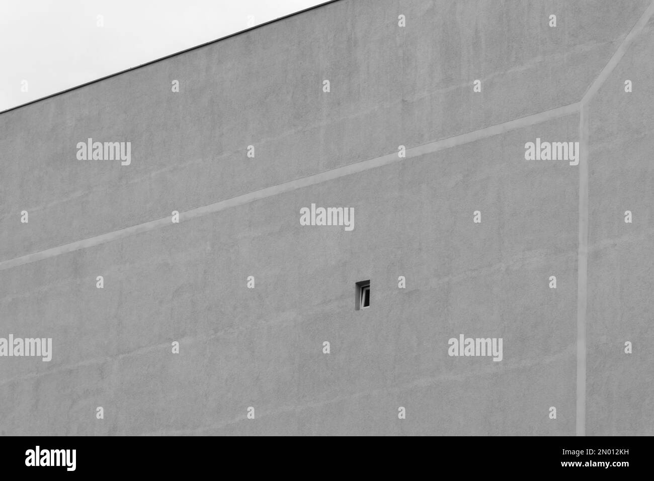 Petite fenêtre dans une grande façade grise Banque D'Images