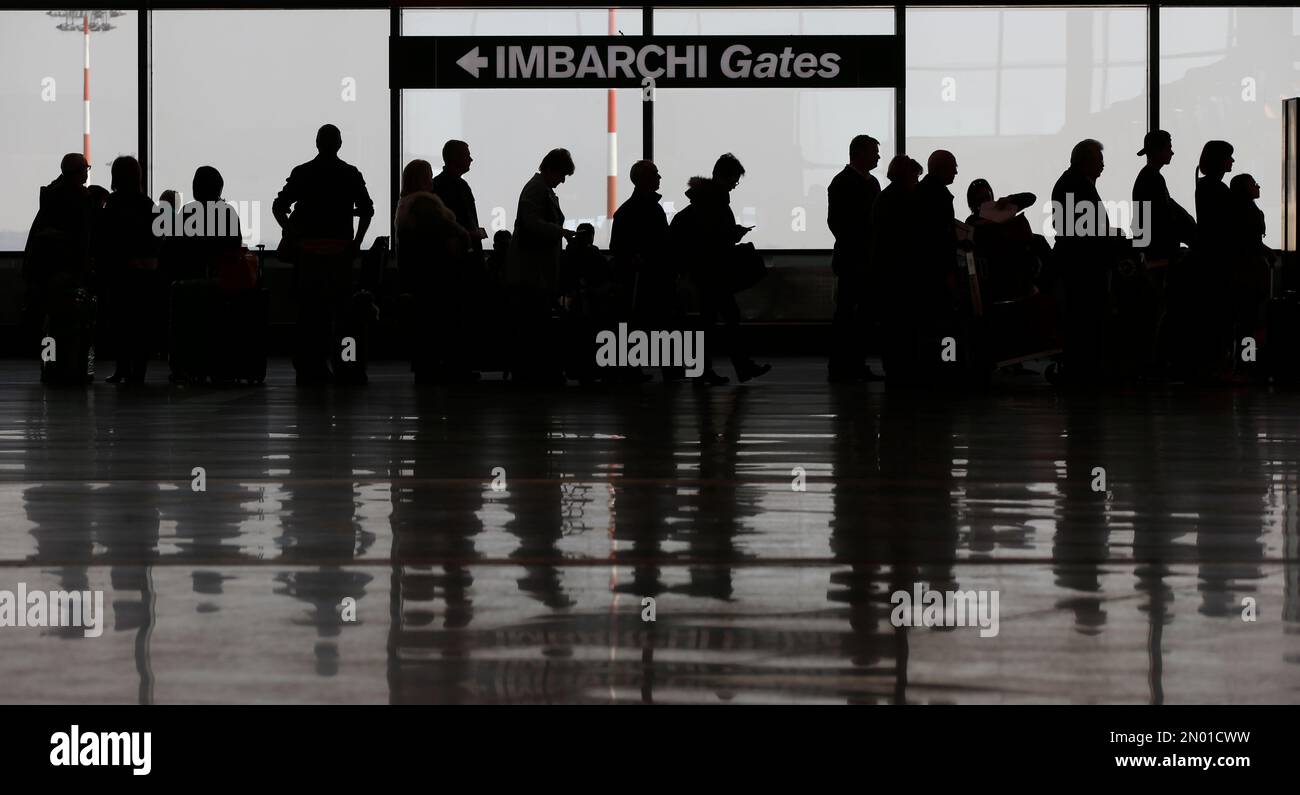 Passengers queue at a check in area of the Milan's Malpensa ...