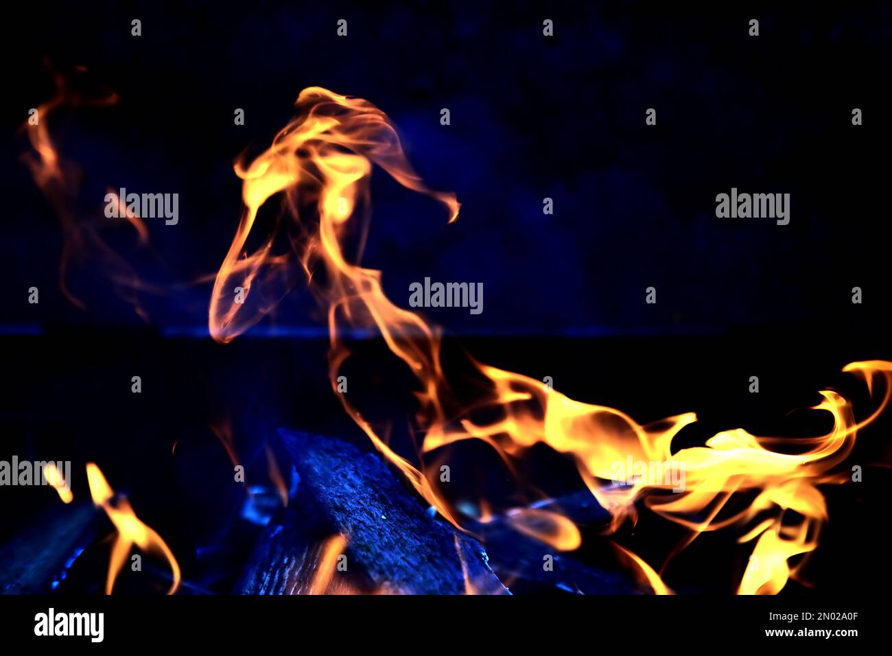 Fond de la flamme dans le four. Langues de feu dans une cheminée en brique. Texture du feu. Banque D'Images