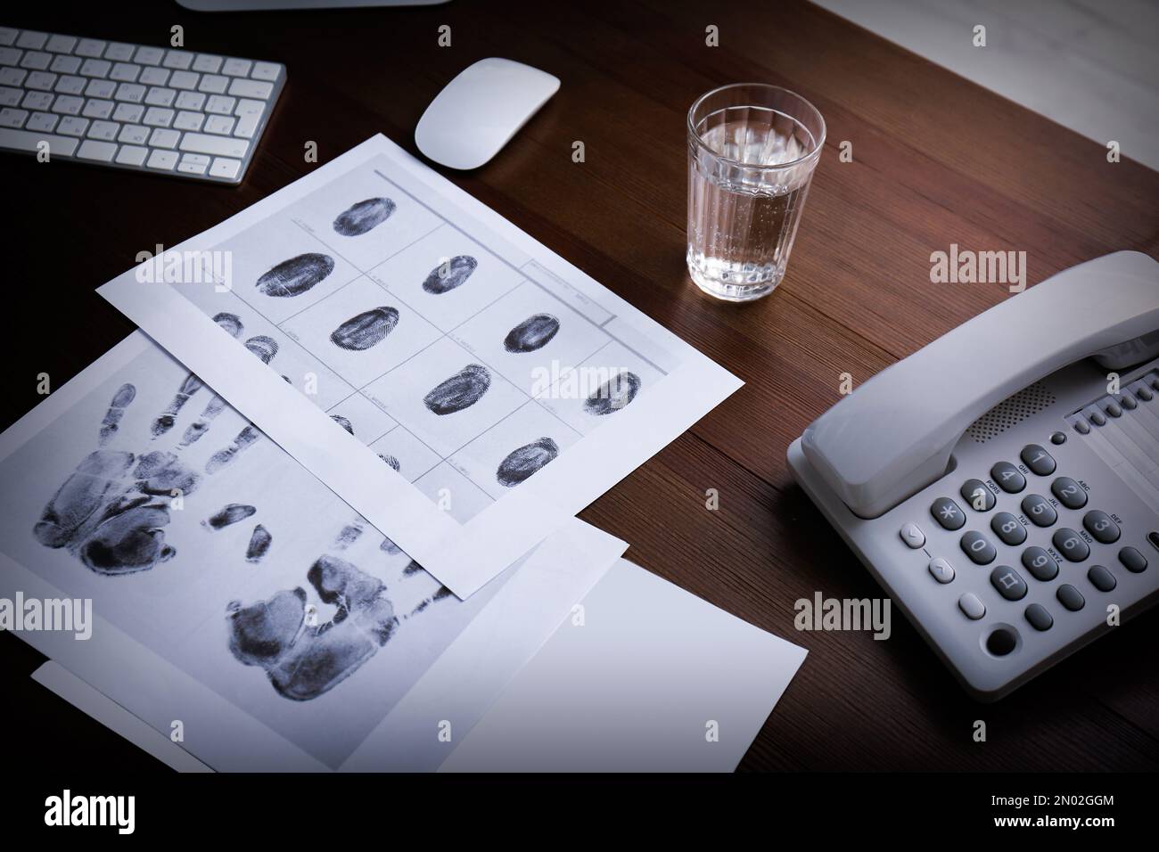 Empreintes digitales, téléphone filaire et verre d'eau sur la table. Agence de détective Banque D'Images
