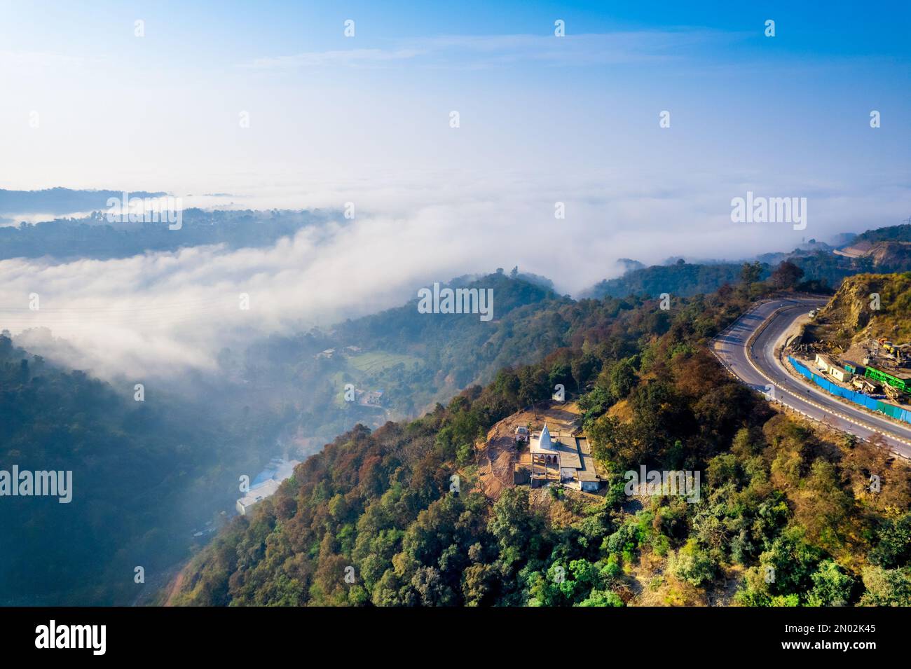 un tir de drone aérien a été effectué depuis l'autoroute de la montagne, avec des voitures qui se déplacent vers la vallée où les nuages de brouillard s'étendent jusqu'à la distance Banque D'Images