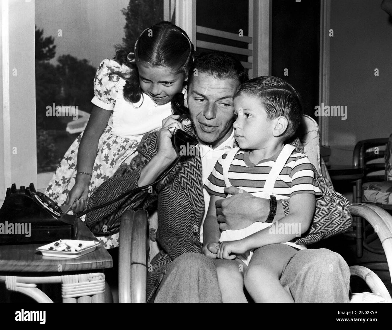 In this 1948 file photo, Frank Sinatra holds a telephone with his