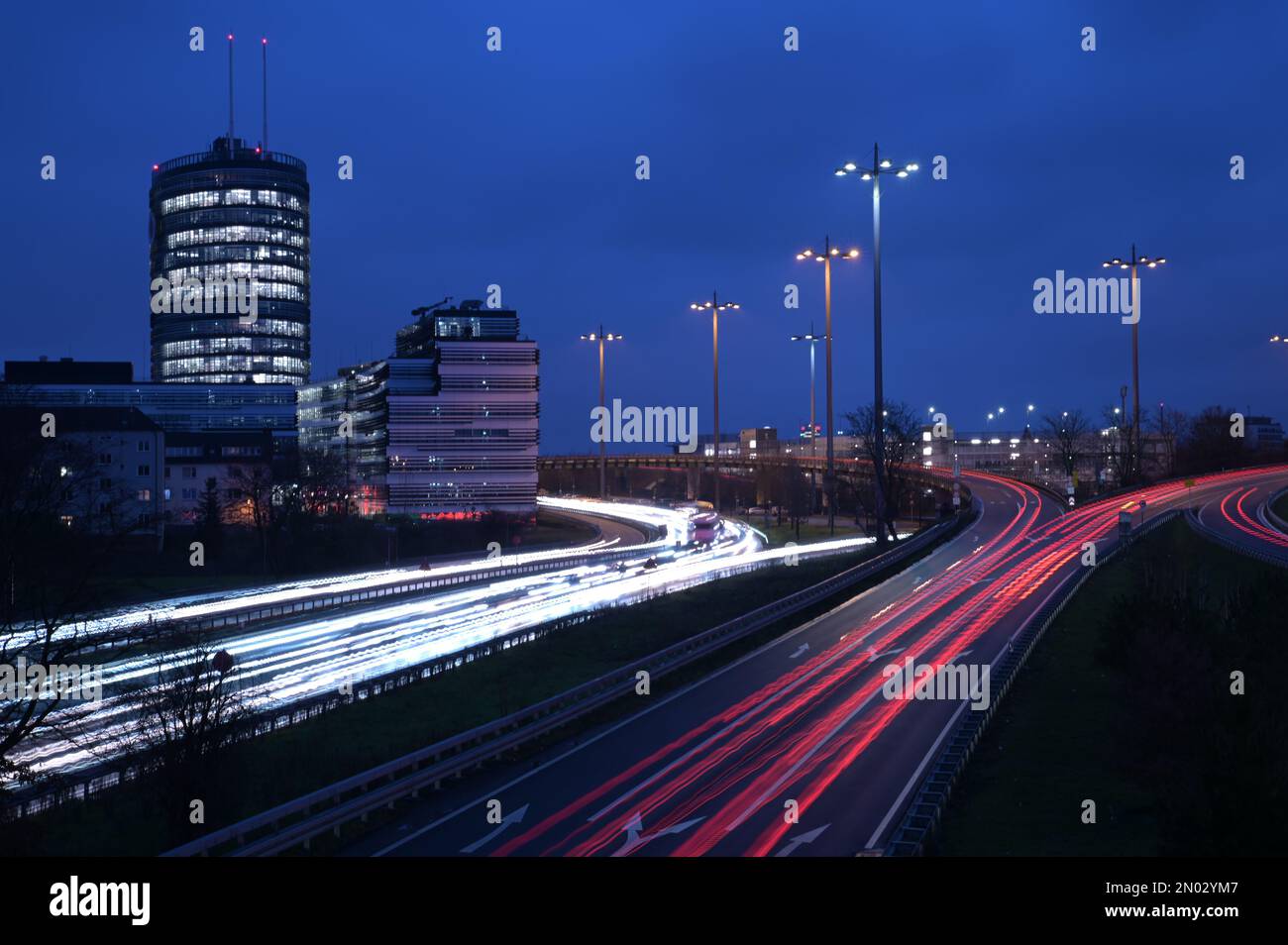 Une longue exposition des sentiers de lumière sur les autoroutes B7 et A52 près de Meerbusch avec la tour Vodafone en arrière-plan à Düsseldorf, en Allemagne Banque D'Images