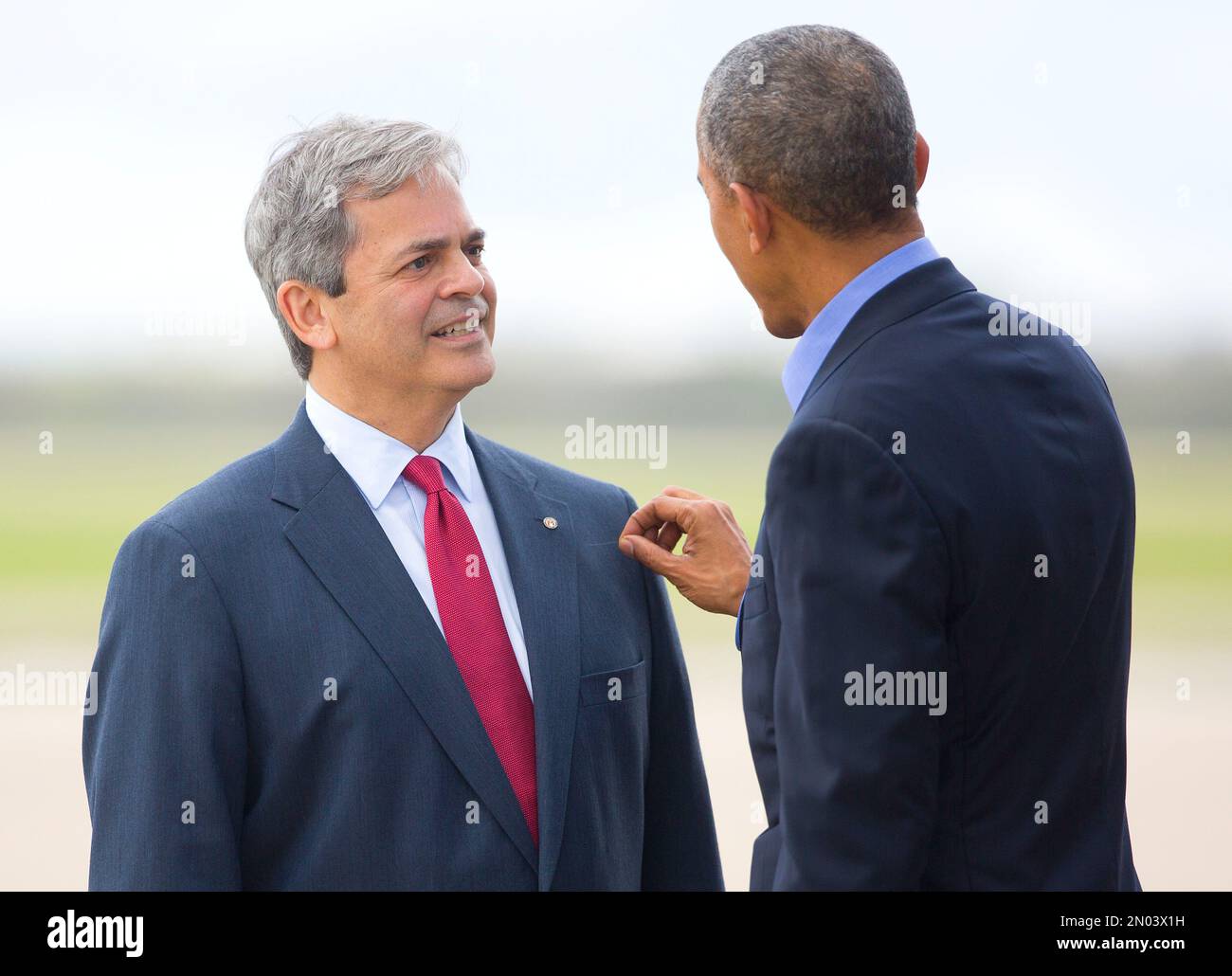 President Barack Obama removes a hair from the suit jacket of Austin, Texas Mayor Steve Adler, who greeted him on the tarmac upon his arrival on Air Force One, Friday, March 11, 2016, at Austin Bergstrom International Airport in Austin, Texas. Obama traveled to Austin, to speak at South by Southwest Festival (SXSW) and attend 2 Democratic National Committee fundraisers. (AP Photo/Pablo Martinez Monsivais) Banque D'Images