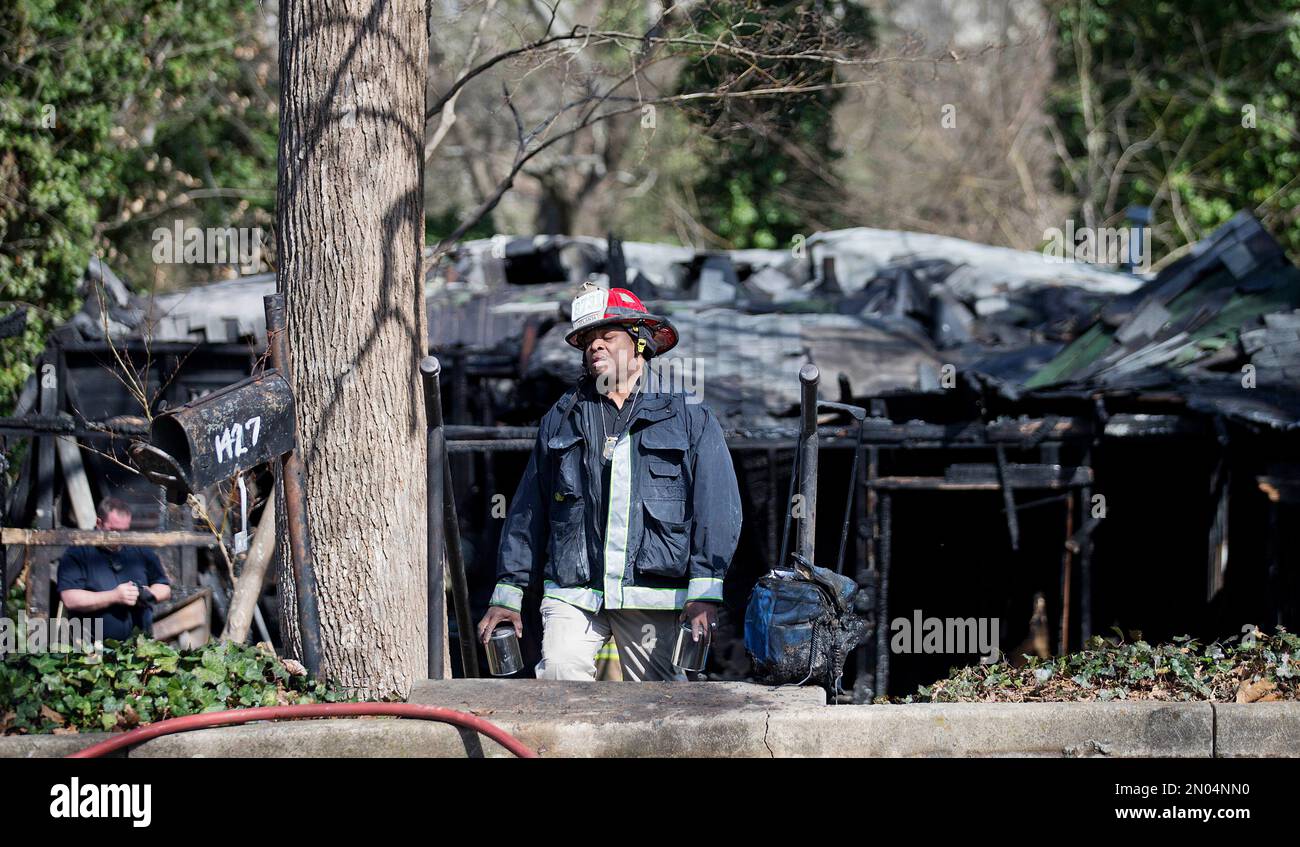 An investigator walks in front of the scene of a house fire where an Atlanta fire spokesman says six people were killed Monday, March 7, 2016, in Atlanta. Atlanta Fire Rescue spokesman Cortez Stafford says four men and two women perished in the Monday morning blaze. He says the cause of the fire has not yet been determined. (AP Photo/David Goldman) Banque D'Images