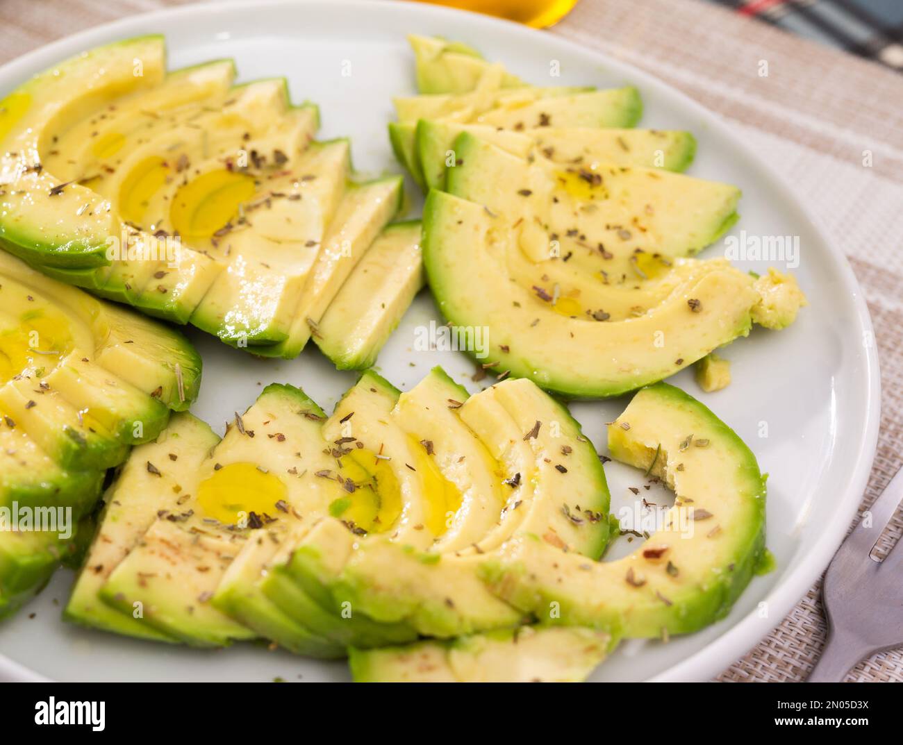 pulpe d'avocat mûre coupée en morceaux saupoudrée de jus de citron sur une assiette Banque D'Images