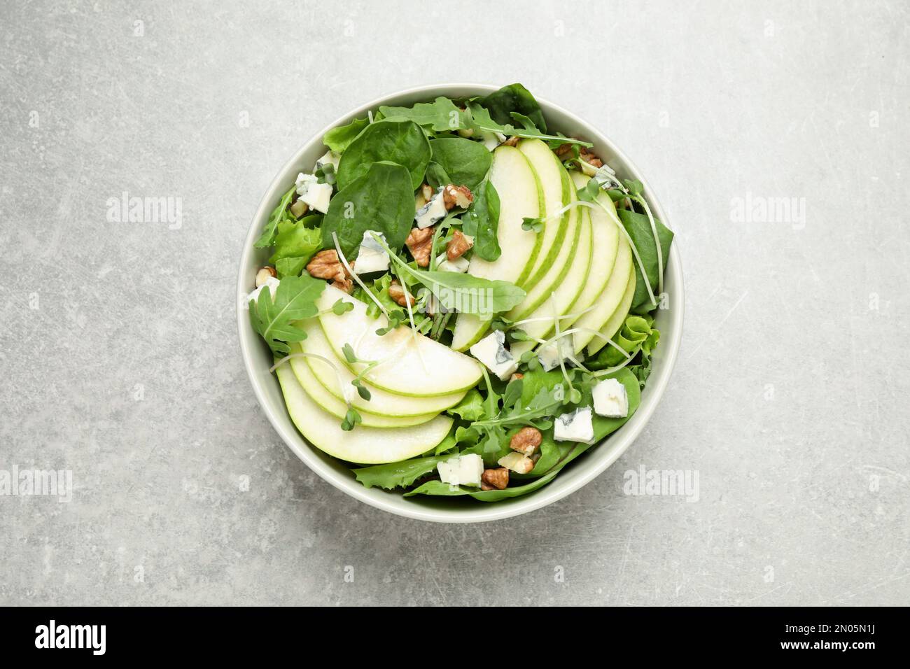 Salade savoureuse avec des tranches de poire sur une table gris clair, vue du dessus Banque D'Images