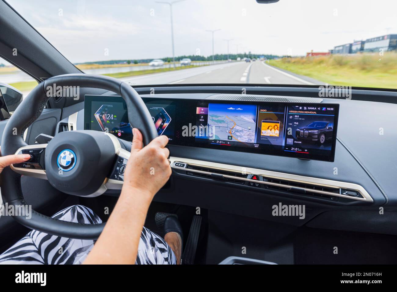 Vue intérieure de la voiture électrique BMW iX40 sur la route. Conducteur femelle dans le véhicule. Suède. Banque D'Images