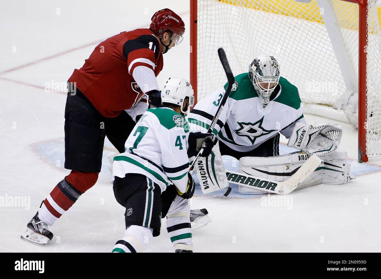 Arizona Coyotes' Martin Hanzal, left, of the Czech Republic, beats Dallas Stars goalie Antti Niemi, right, of Finland, and Johnny Oduya (47), of Sweden, to score a goal during the third period of an NHL hockey game Thursday, Feb. 18, 2016, in Glendale, Ariz. The Coyotes defeated the Stars 6-3. (AP Photo/Ross D. Franklin) Banque D'Images