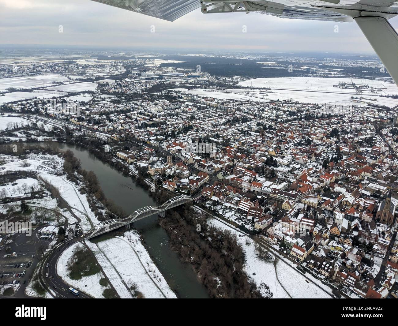 Vue aérienne du Neckar et du pont à Seckenheim (Mannheim) pendant l'hiver couvert de neige. Avion léger survolant la ville après le départ Banque D'Images