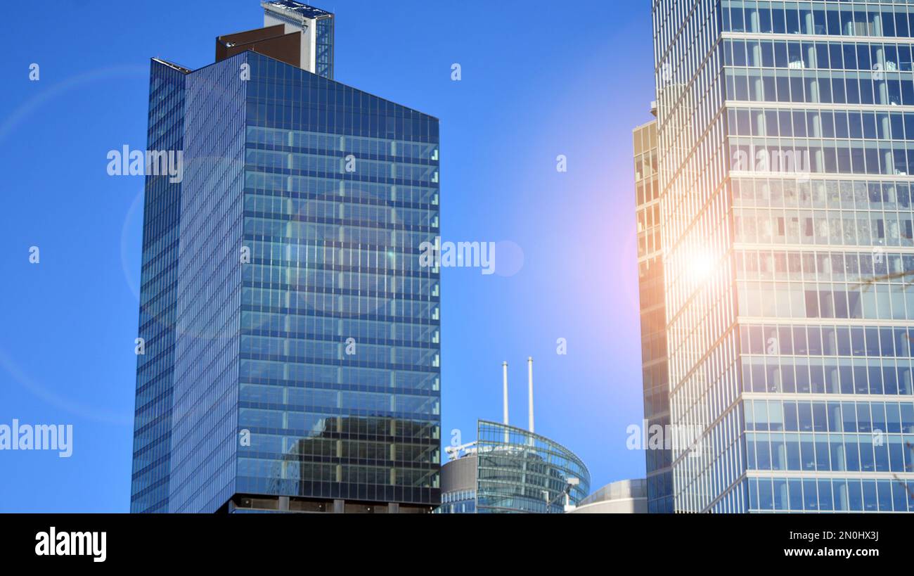 Mur-rideau bleu en verre teinté et constructions en acier sous ciel bleu. Fragment d'un bâtiment. Façades en verre par jour ensoleillé Banque D'Images