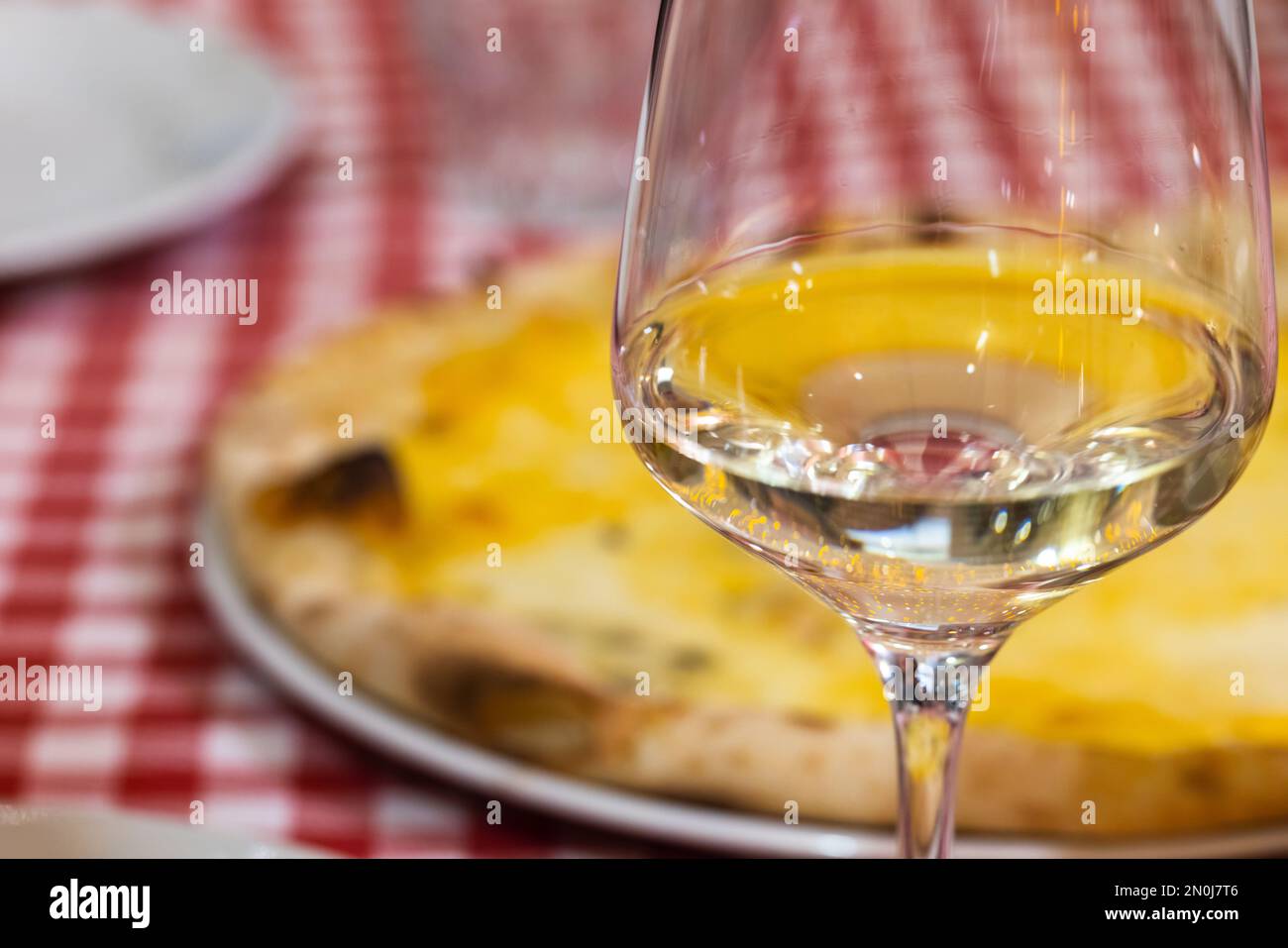 Un verre de vin blanc se tient sur une table dans un restaurant italien, photo de près avec une mise au point douce sélective Banque D'Images