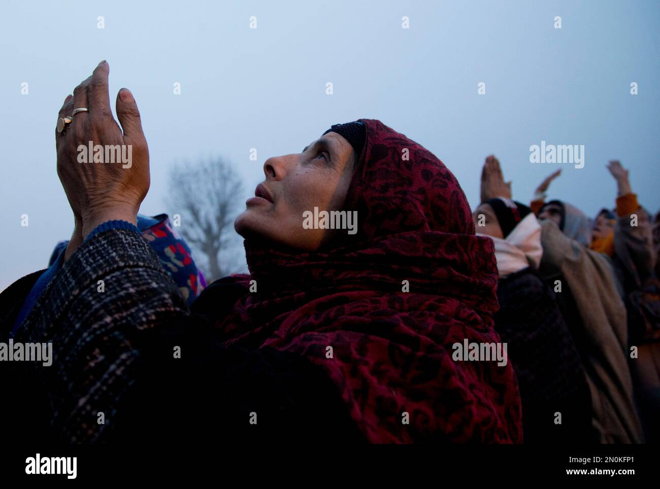 Kashmiri Muslim women raise their hands as they look towards a holy ...
