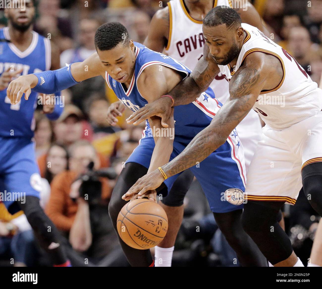 Philadelphia 76ers Richaun Holmes, left, and Cleveland Cavaliers' LeBron James battle for a loose ball in the first half of an NBA basketball game Sunday, Dec. 20, 2015, in Cleveland. (AP Photo/Tony Dejak) Banque D'Images