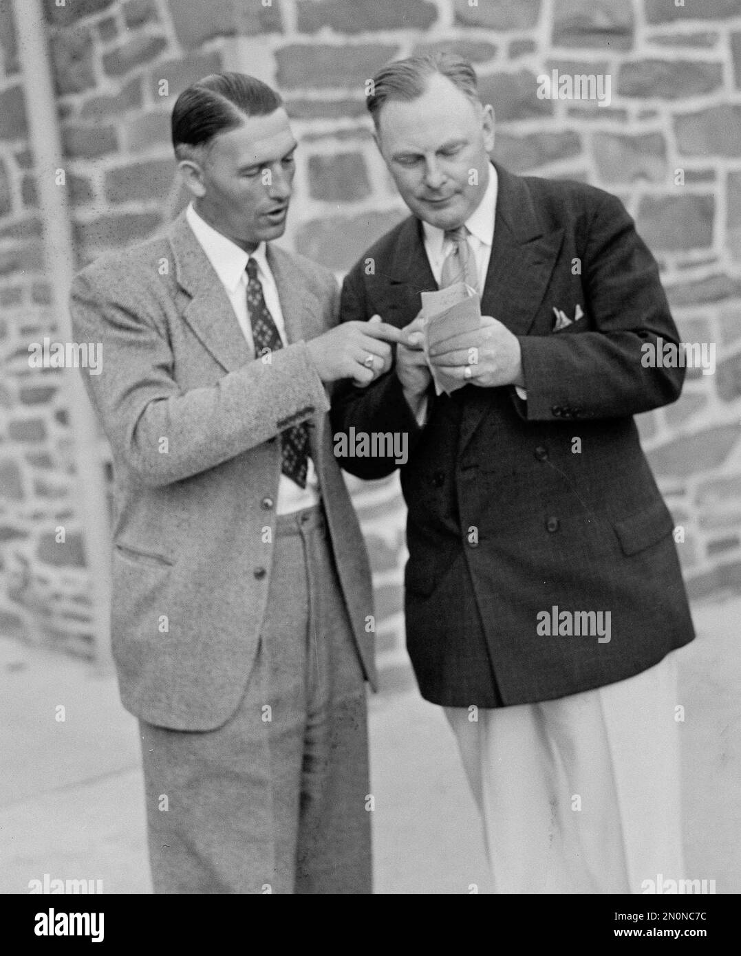 Al Ulbrickson, left, coach of the University of Washington crew team, talks things over with Rusty Callow, Pennsylvania coach who is "covering" the Poughkeepsie Regatta the Seattle Times newspaper, in Poughkeepsie, N.Y.,June 17, 1940. Penn's crew team will not compete in the collegiate rowing classic. (AP Photo/Ed Alley) Banque D'Images