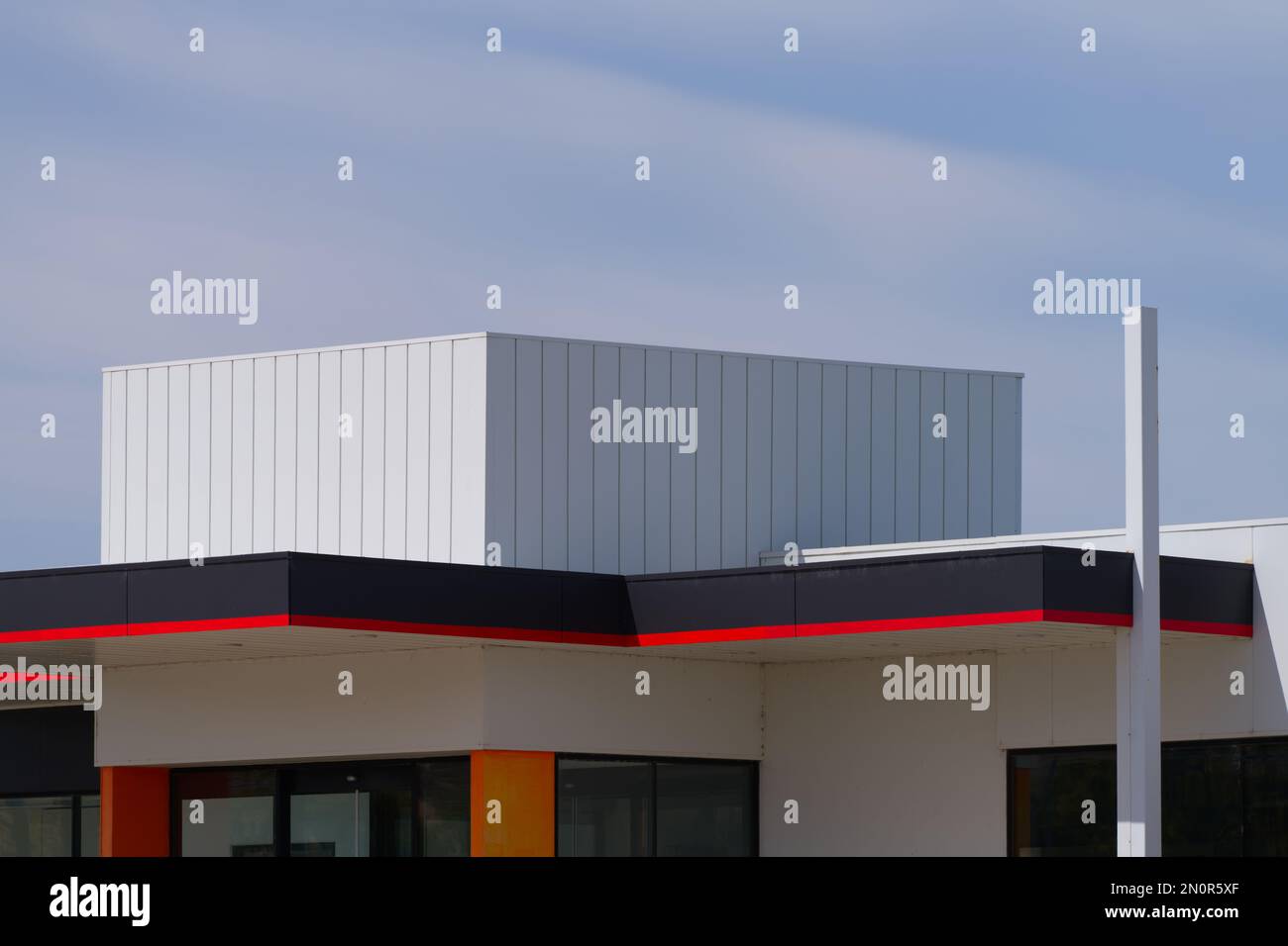 Station essence design montrant une structure abstraite de bâtiment avec des couleurs rouges et fond gris ciel, Victoria Australie. Banque D'Images