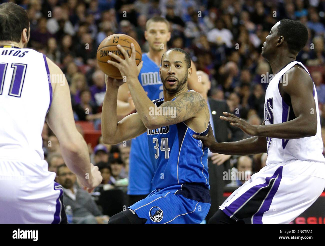 Dallas Mavericks guard Devin Harris, center, goes to the basket between Sacramento Kings' Kosta Koufos, left, and Darren Collison during the first quarter of an NBA basketball game in Sacramento, Calif., Monday, Nov. 30, 2015. (AP Photo/Rich Pedroncelli) Banque D'Images