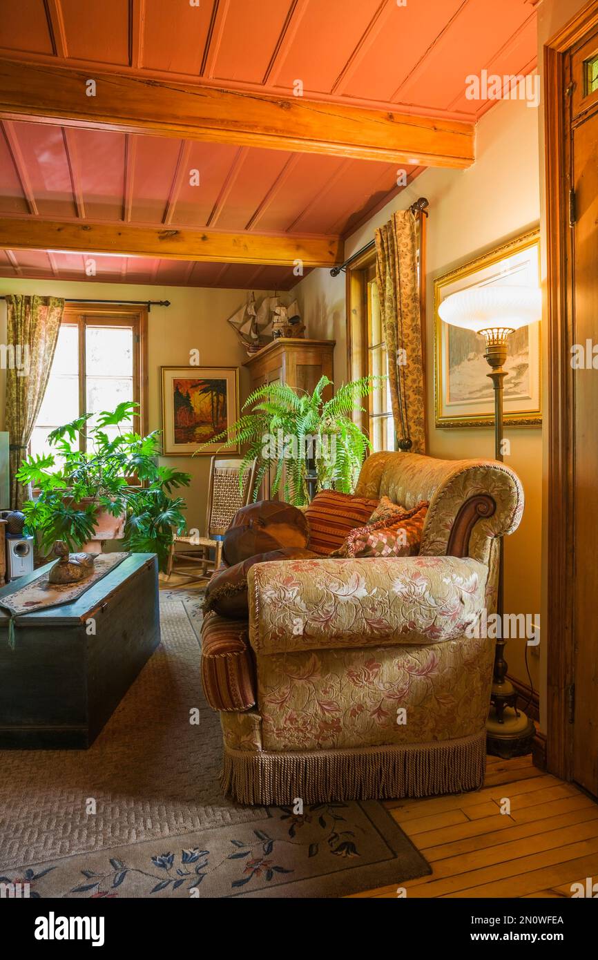 Chambre familiale avec table basse coffre de rangement en bois antique, canapé rembourré, fauteuil à bascule tissé et armoire en pin à l'intérieur de la vieille maison circa1850. Banque D'Images